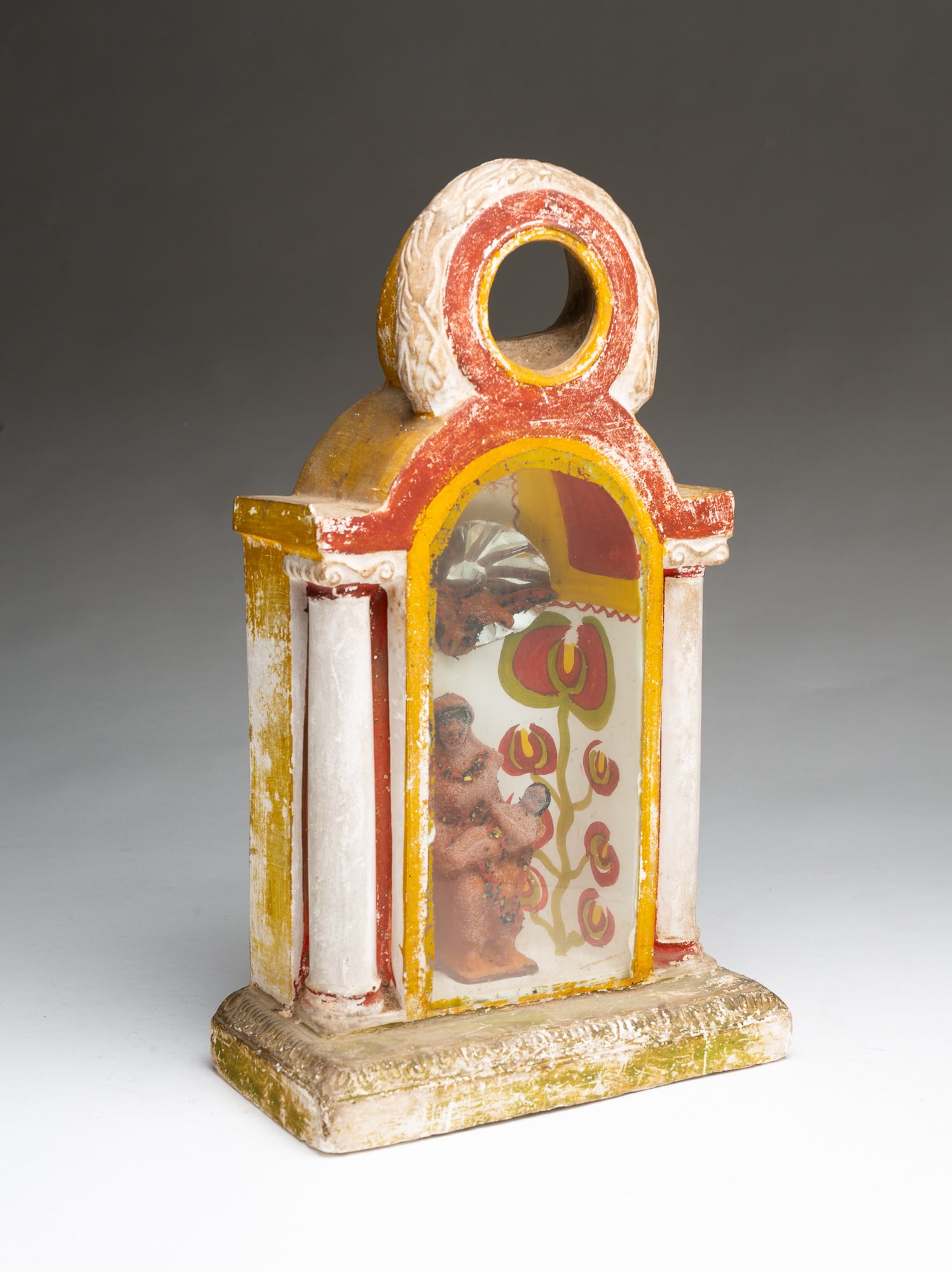 SCARCE PENNSYLVANIA CHALKWARE WATCH HUTCH DEPICTING THE MADONNA AND CHILD.: SCARCE PENNSYLVANIA CHALKWARE WATCH HUTCH DEPICTING THE MADONNA AND CHILD. American, 19th Century. Having an opening at the top for a watch atop an enclosed niche with figures of Mary holding baby