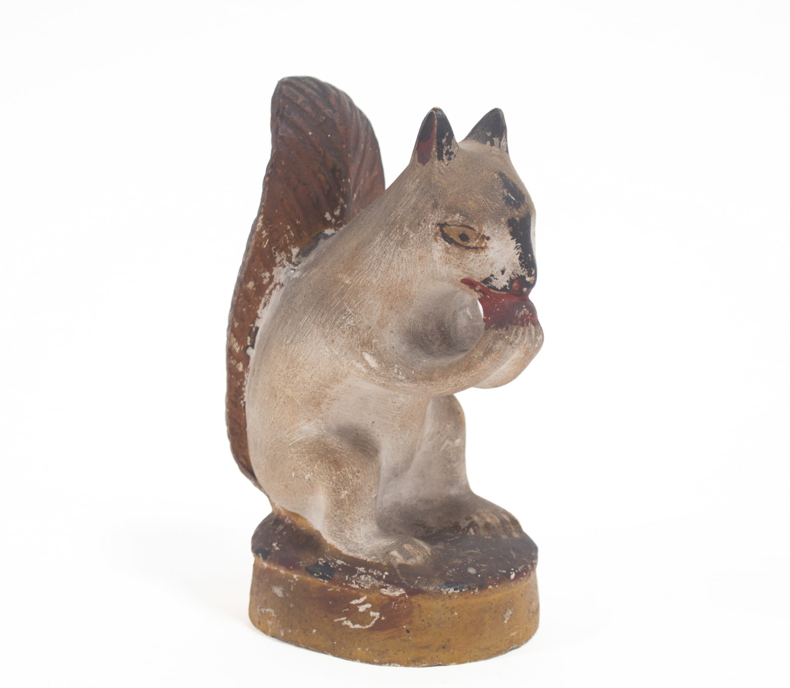EARLY CHALKWARE SQUIRREL.: EARLY CHALKWARE SQUIRREL. American, Second half 19th Century. Full-bodied squirrel sitting up eating a nut on oval base with original paint. 7"h. Provenance: Nancy Goff (Alliance, Ohio).