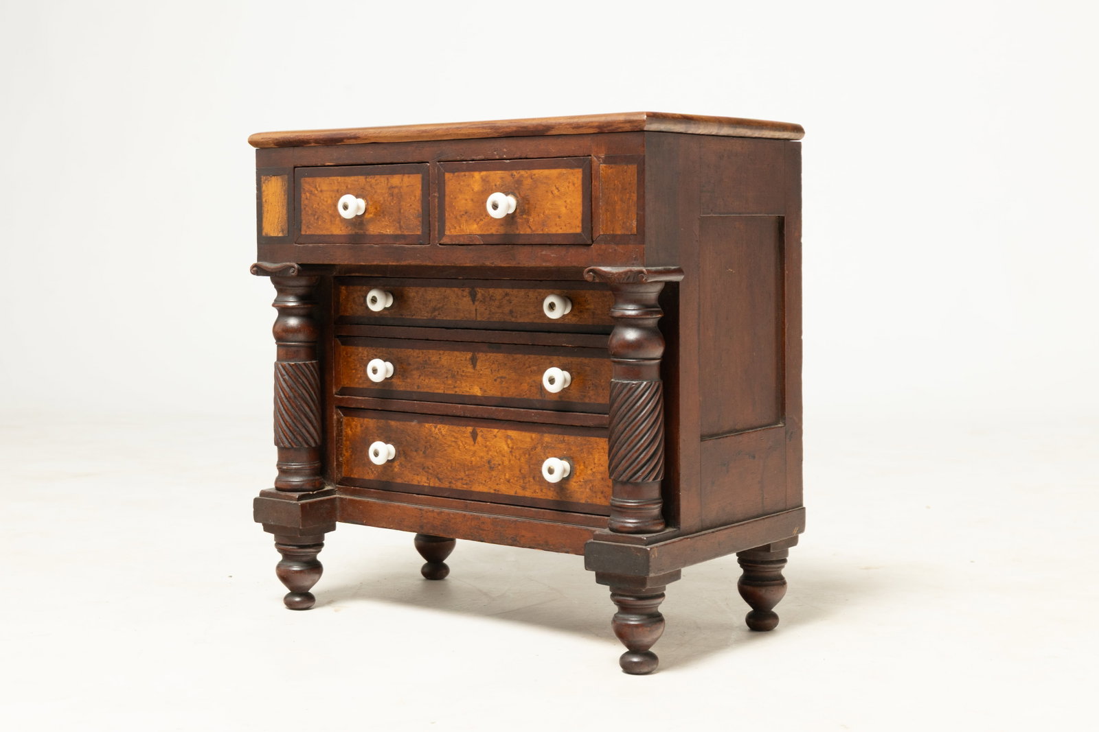 BEAUTIFULLY PROPORTIONED DOLL SIZE TRANSITIONAL CHEST OF DRAWER.: BEAUTIFULLY PROPORTIONED DOLL SIZE TRANSITIONAL CHEST OF DRAWER. American, second quarter 19th Century. Mahogany, mahogany, and birdseye maple veneer and pine secondary. Sheraton to Empire. Paneled en