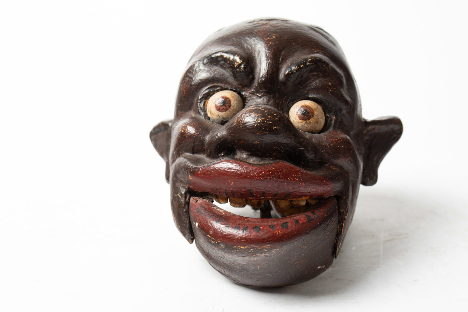 FOLK ART BLACK AMERICANA PUPPET HEAD.: FOLK ART BLACK AMERICANA PUPPET HEAD. American, early 20th Century. With carved and painted facial features including moving eyes and mouth; 8"h. 8.25"w. Provenance: Nancy Goff (Alliance, Ohio).