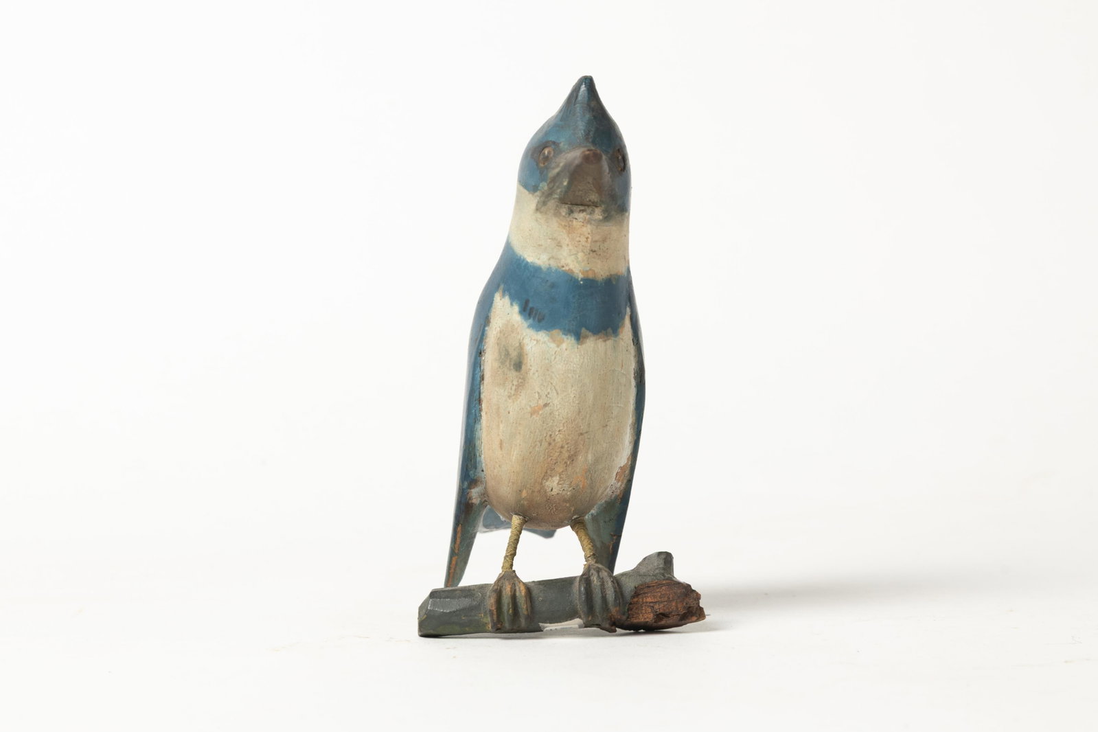 CARVED AND PAINTED BLUE JAY ON TWIG.: CARVED AND PAINTED BLUE JAY ON TWIG. American, Late 19th or early 20th Century. A carved blue jay resting on a twig with wonderful painted decoration. 6.5"h. Provenance: Nancy Goff (Alliance, Ohio).
