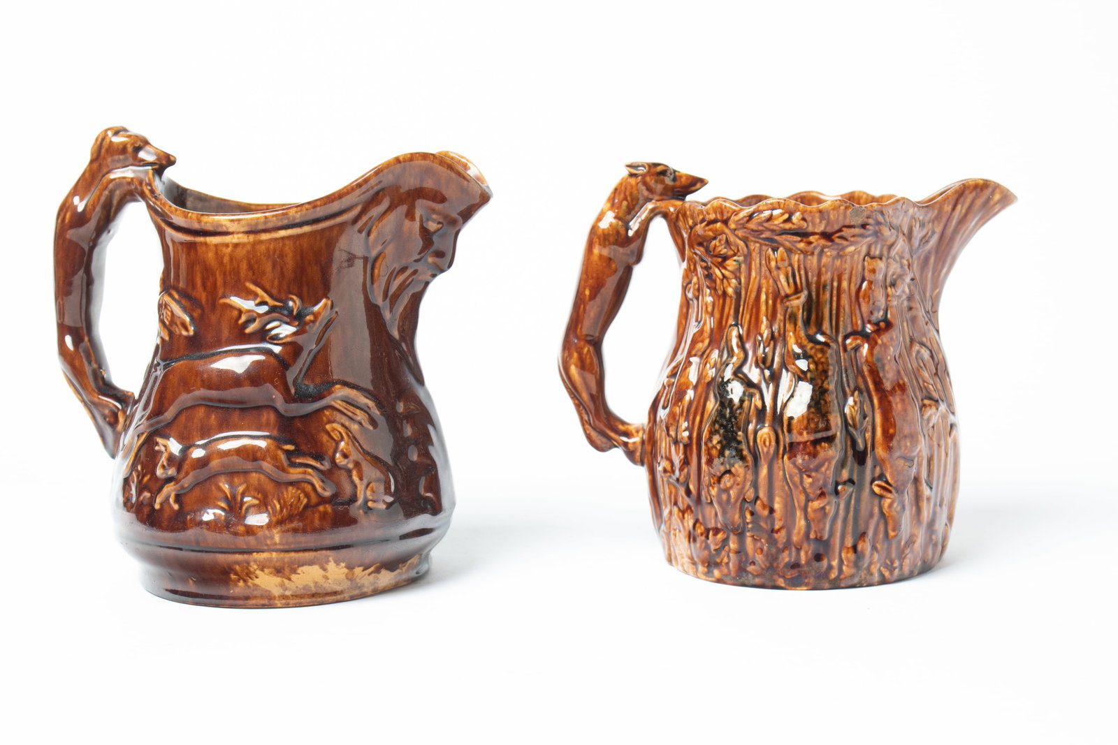 TWO YELLOWWARE PITCHERS WITH ROCKINGHAM GLAZE AND HOUND HANDLES. (1 of 4)