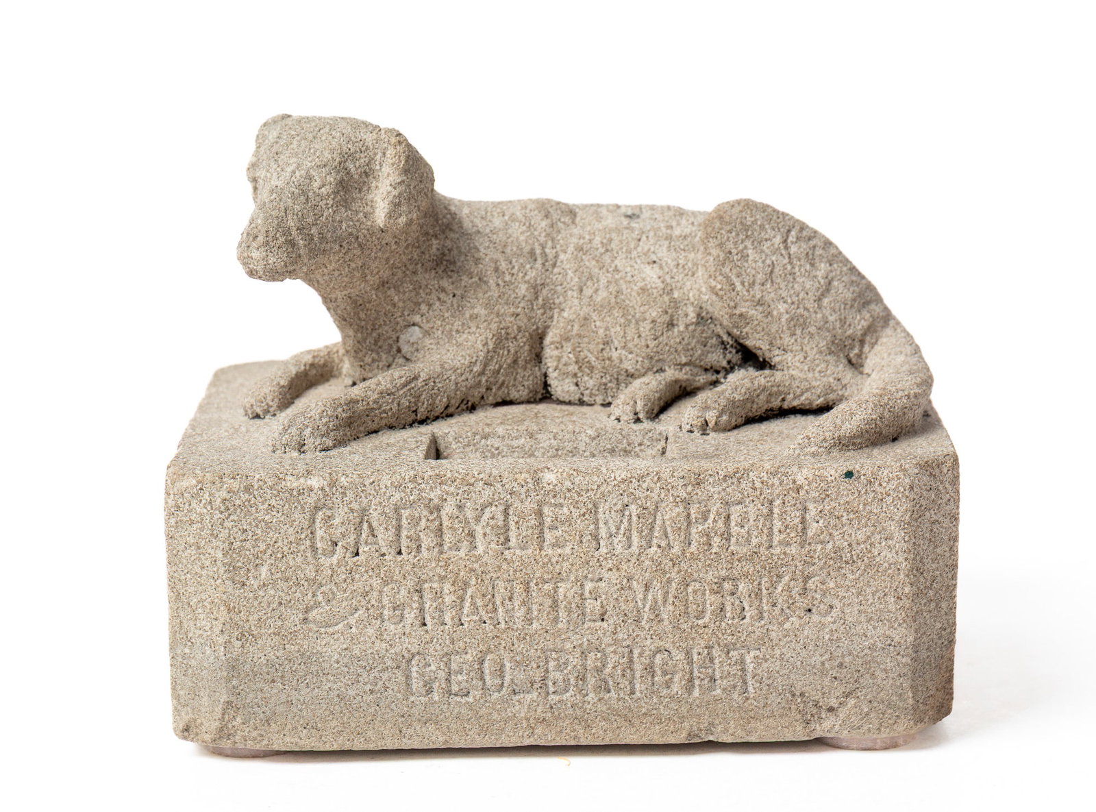 "CARLYLE MARBLE & GRANITE WORKS" CARVED GRANITE RECUMBENT DOG ADVERTISING SCULPTURE.: "CARLYLE MARBLE & GRANITE WORKS" CARVED GRANITE RECUMBENT DOG ADVERTISING SCULPTURE. American, 20th Century. Depicting a dog laying on a rectangular plinth, the front of which is etched "CARLYLE MARBL