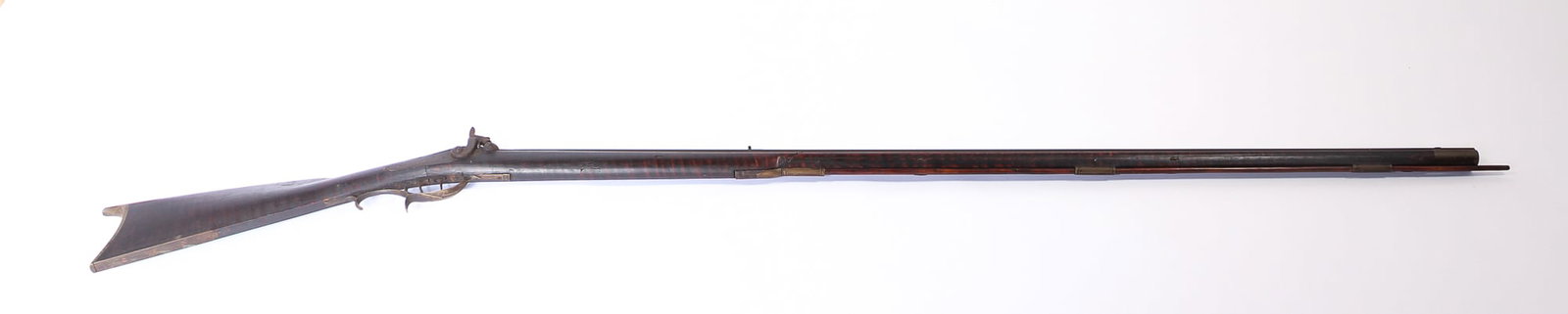 FULL STOCK TIGER MAPLE RIFLE.: FULL STOCK TIGER MAPLE RIFLE. American, mid- 19th Century. Octagonal .32 caliber barrel, double set triggers, carved cheek rest, brass thimbles, trigger guard, and butt plate. As found, original