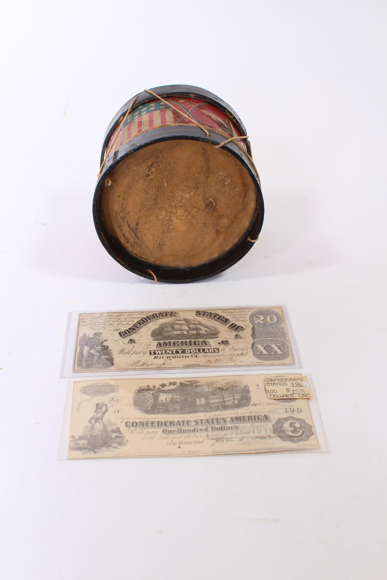 CONFEDERATE CURRENCY, 100 DOLLAR BILL AND 20 DOLLAR BILL, TOGETHER WITH A PATRIOTIC THEME WOOD AND: CONFEDERATE CURRENCY, 100 DOLLAR BILL AND 20 DOLLAR BILL, TOGETHER WITH A PATRIOTIC THEME WOOD AND TIN LITHO TOY DRUM. American (Richmond, Virginia), 19th Century. 100 dollar bill, no. 65224, signed b