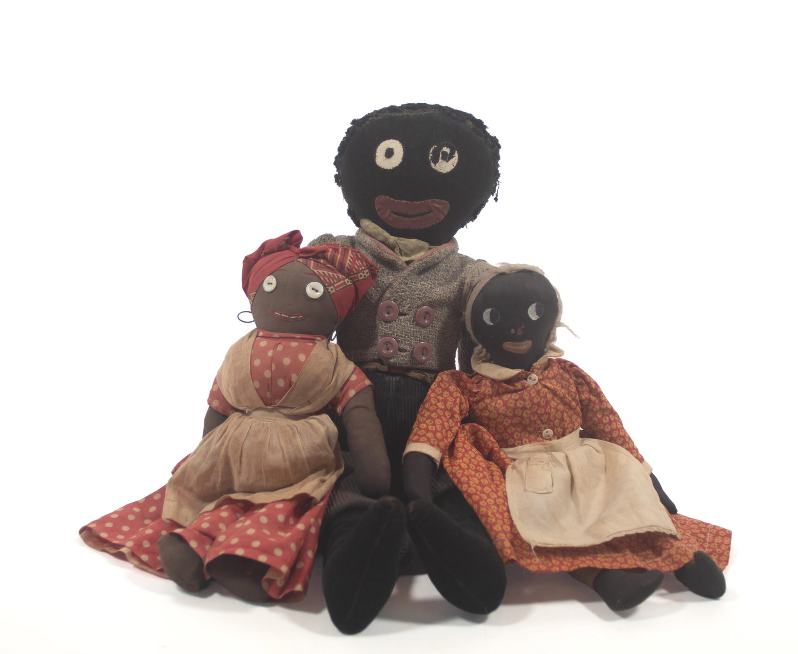 THREE FOLK ART CLOTH BLACK AMERICANA DOLLS.: THREE FOLK ART CLOTH BLACK AMERICANA DOLLS. American, late 19th or early 20th century. A Golliwog doll with chenille hair, a velvet body, cloth eyes, an oilcloth mouth, wearing a wool jacket and cordu