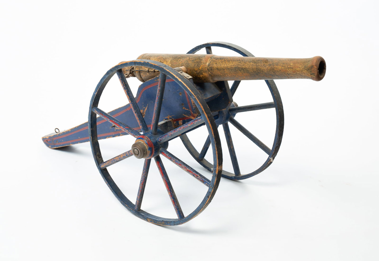 AMERICAN PAINT-DECORATED WOOD TOY CANNON.: AMERICAN PAINT-DECORATED WOOD TOY CANNON. Late 19th or early 20th Century. The blue-painted carriage with red pinstripes. 10.5"h. 7.5"w. 22"d. Provenance: The Lifetime Collection of Richard & Phyllis 