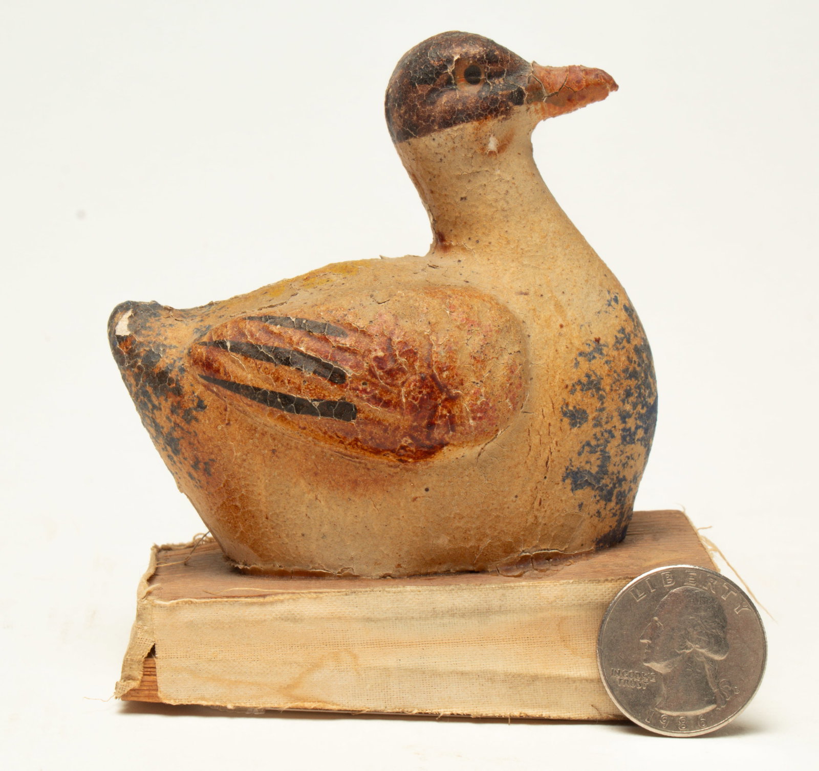 PAINTED DUCK PIPSQUEAK.: PAINTED DUCK PIPSQUEAK. Germany, early 20th Century. A painted composition duck with a red bill, red and black on wings, black head, and speckled breast on top of a squeaker. 4"h. 3.25"l. Provenance: