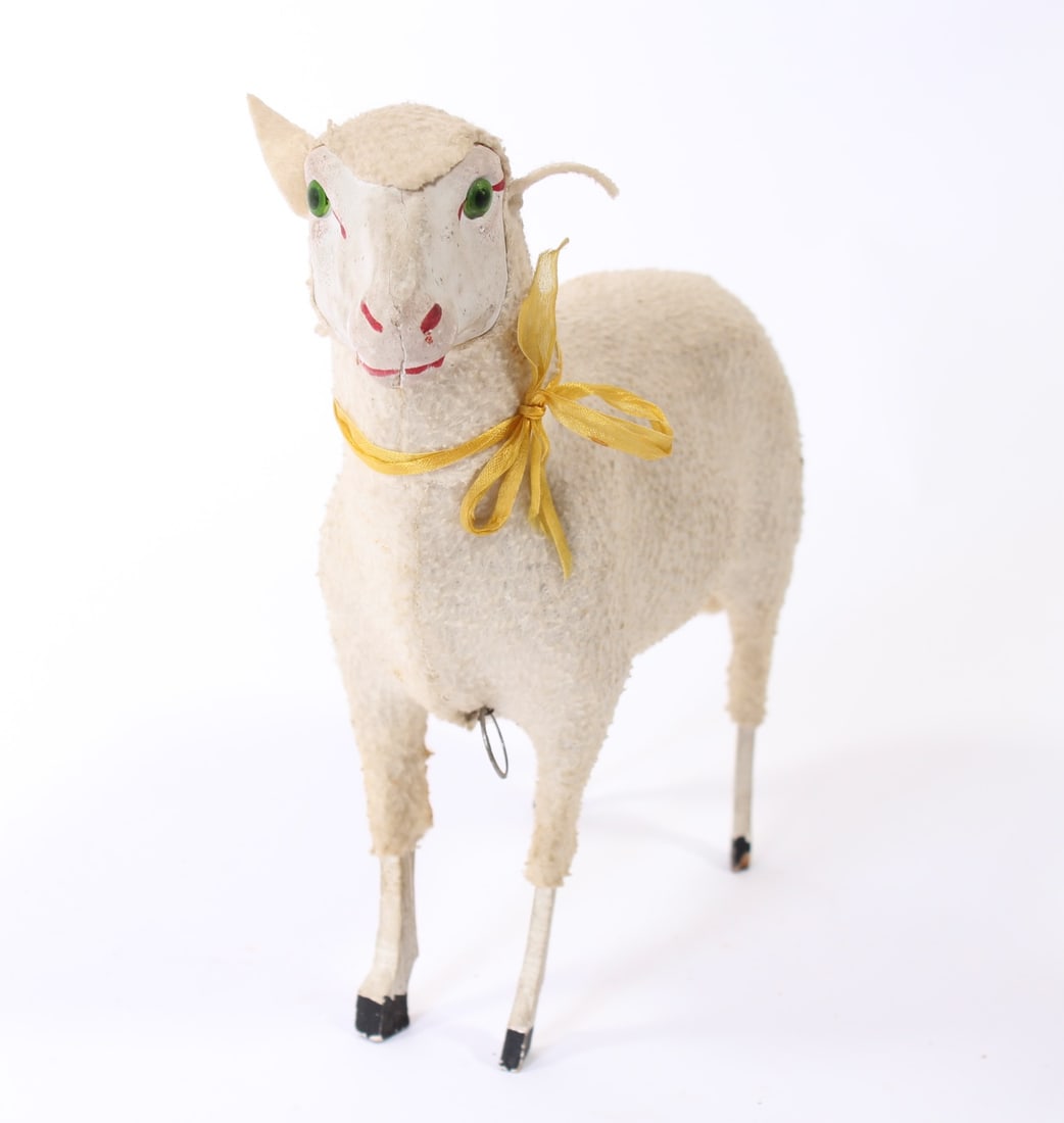 LARGE WOOLY SHEEP WITH GLASS EYES.: LARGE WOOLY SHEEP WITH GLASS EYES. Germany, 20th Century. Wooden sheep with composition face, green glass eyes, woolly body, painted wooden legs, and wearing a yellow ribbon around its neck. Pull at b
