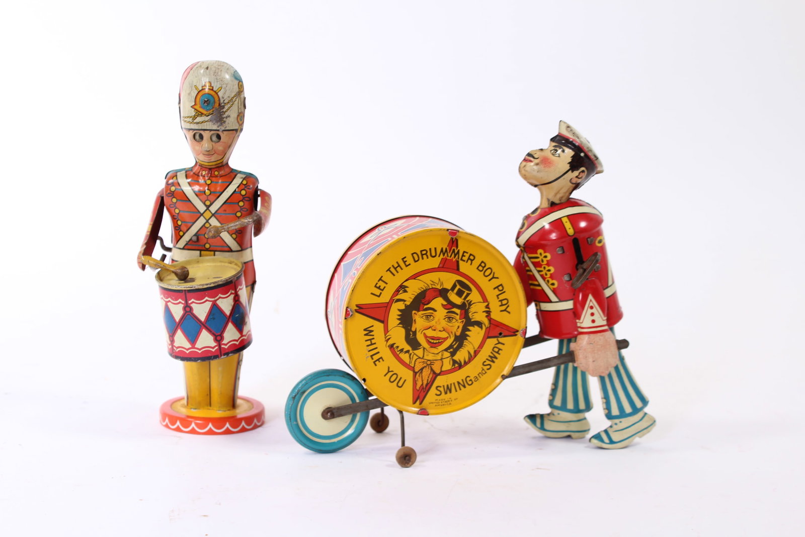 TWO LOUIS MARX (NEW YORK, NEW YORK) TIN LITHO WINDUP DRUMMER BOYS.: TWO LOUIS MARX (NEW YORK, NEW YORK) TIN LITHO WINDUP DRUMMER BOYS. American, 20th Century. Walking drummer boy with articulated neck playing a large bass drum with his right hand, the bass drum readin