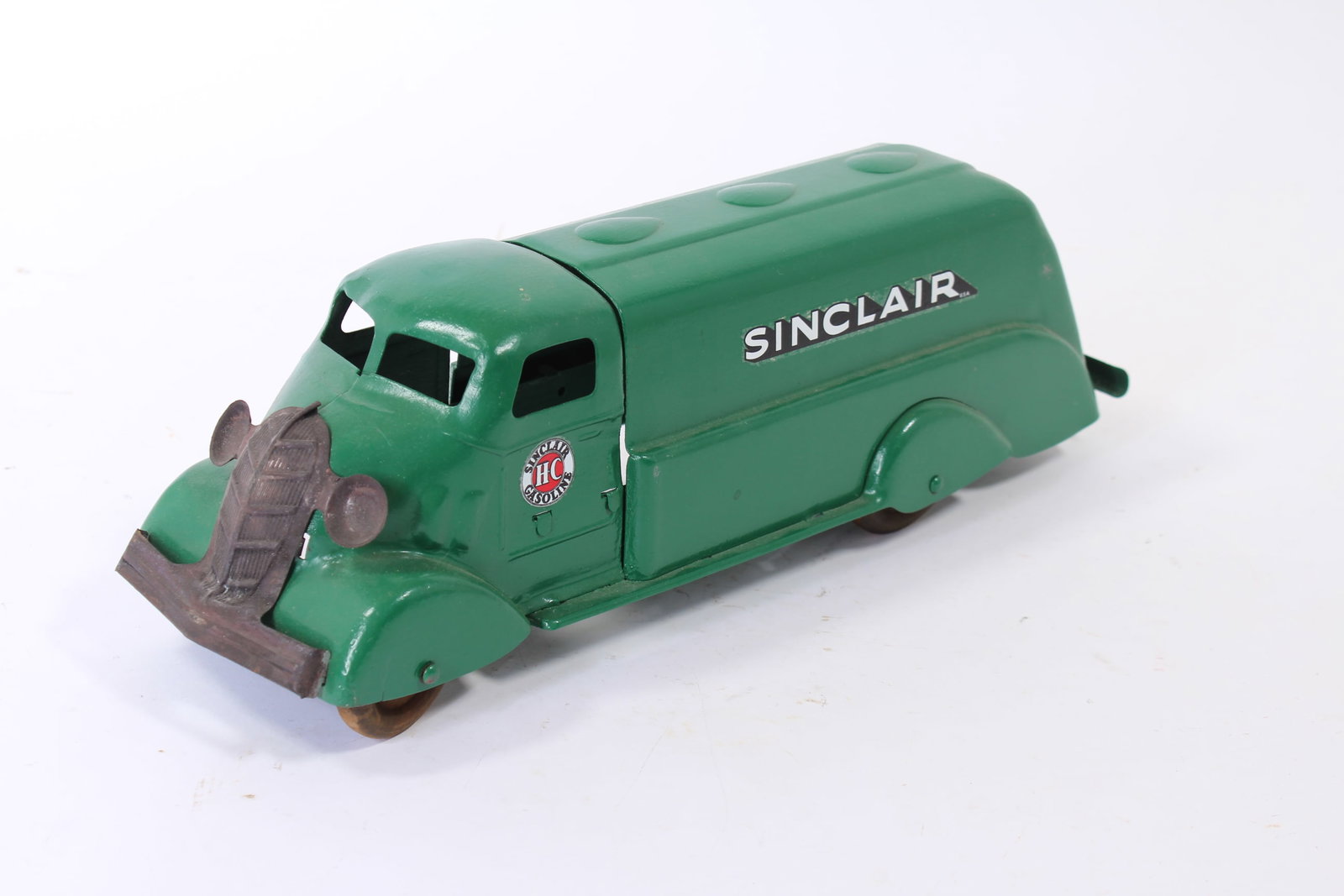 PRESSED STEEL SINCLAIR GASOLINE TRUCK.: PRESSED STEEL SINCLAIR GASOLINE TRUCK. American, 20th Century. Green truck with Sinclair logos on sides, detailed front grill, and four wooden wheels. Likely restored. 5.75"h. 5.25"w. 17.5"l.