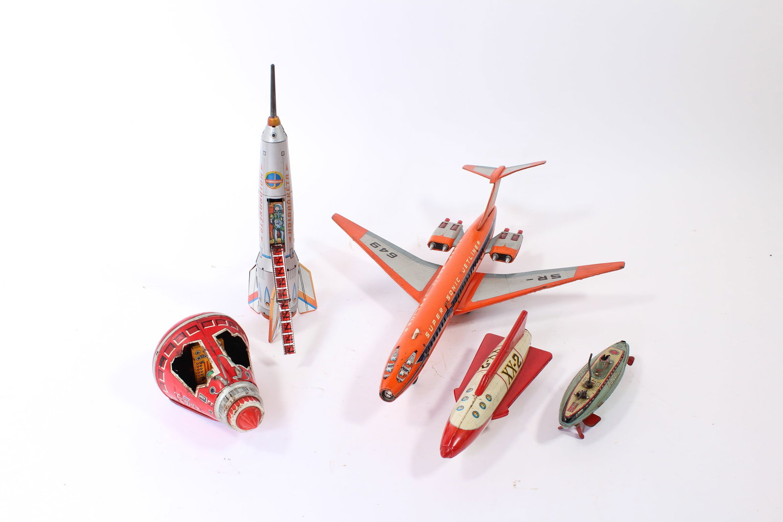 A JAPANESE SUPER SONIC JETLINER AND HOLDRAKETA TIN LITHO TOYS.: A JAPANESE SUPER SONIC JETLINER AND HOLDRAKETA TIN LITHO TOYS. 20th Century. Includes a Super Sonic Jetliner, marked; a Holdraketa spaceship, unmarked; an SH Friendship 7 space capsule, marked; a