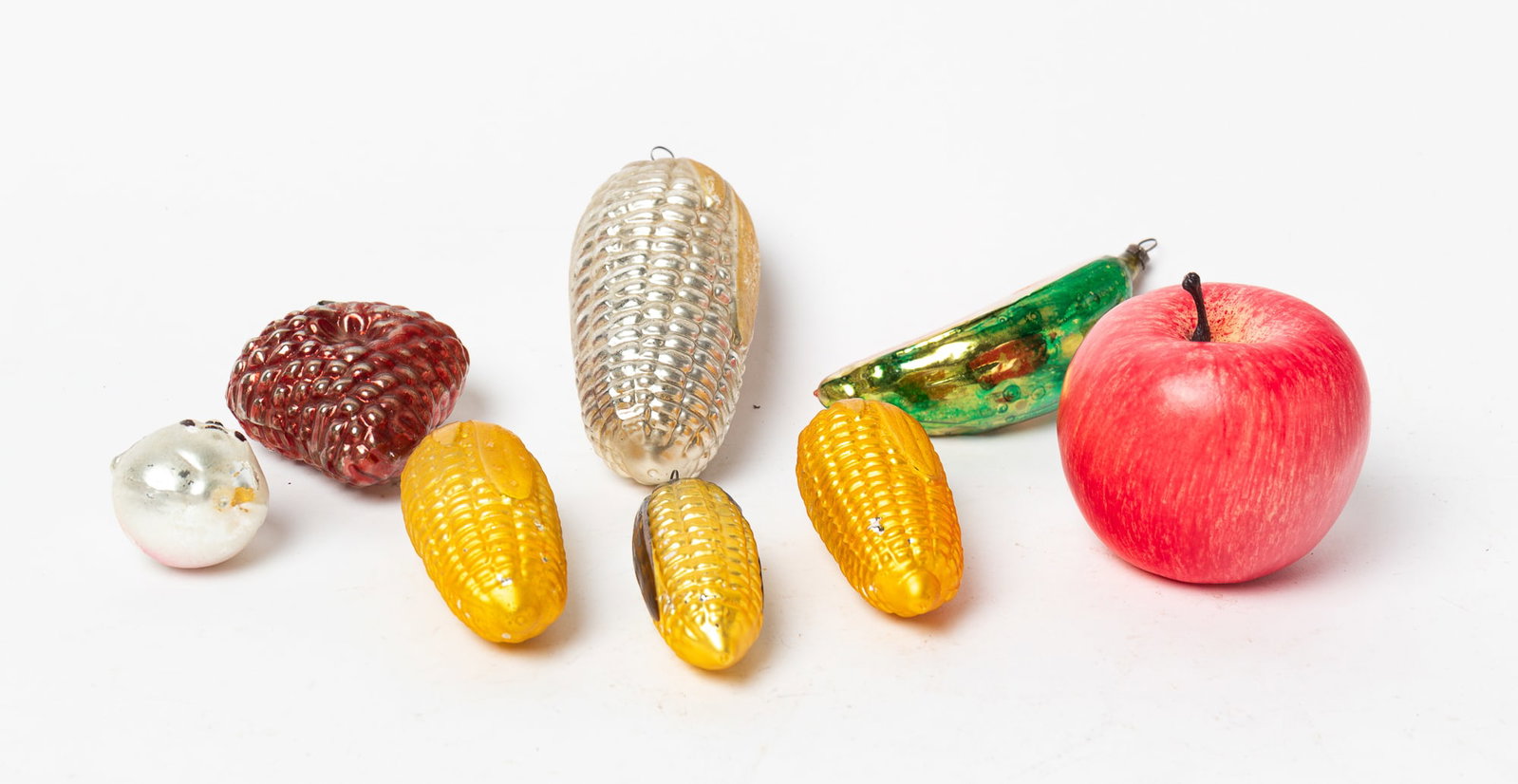 EARLY GERMAN GLASS FOOD THEMED ORNAMENTS.: EARLY GERMAN GLASS FOOD THEMED ORNAMENTS. Germany, early 20th Century. Includes four ears of corn, a cluster of grapes, a pear with a face and a watermelon slice. Largest, 5"l. Provenance: Nancy Goff 