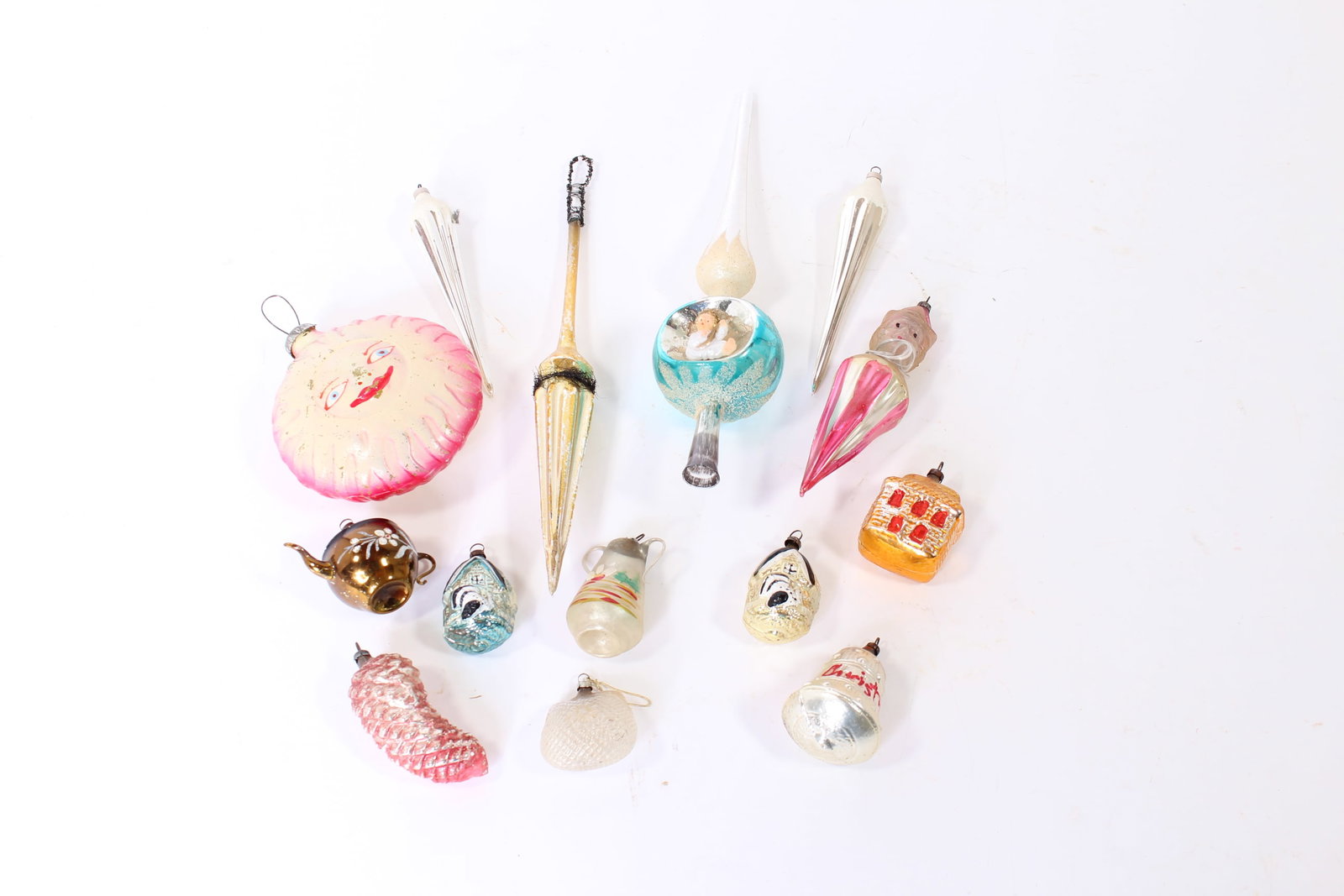 GROUP OF EARLY GLASS CHRISTMAS ORNAMENTS.: GROUP OF EARLY GLASS CHRISTMAS ORNAMENTS. Germany, early 20th Century. Includes a blue and white tree topper with an angel, a long hanging spike, two silver and white icicles, three houses, two teapot