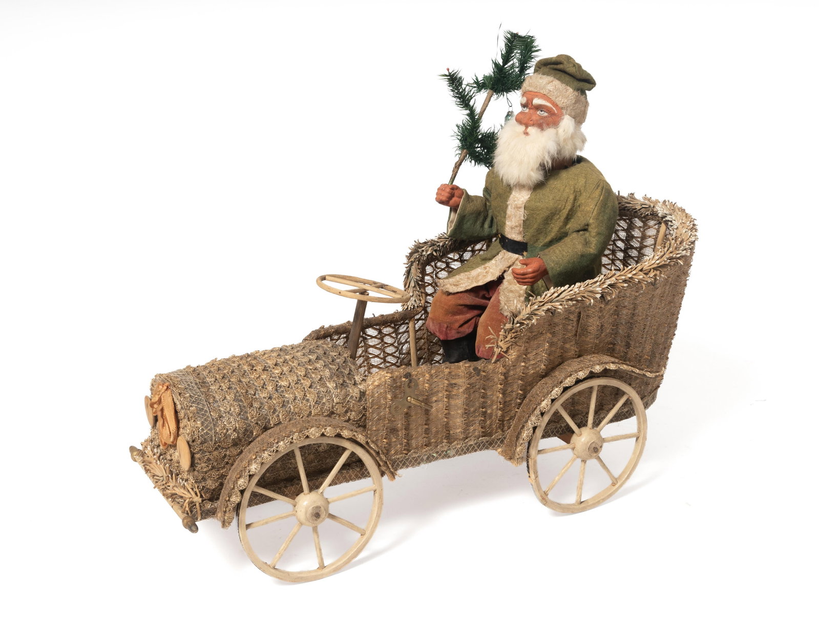 LARGE CLOCKWORK SANTA IN DECORATED CAR.: LARGE CLOCKWORK SANTA IN DECORATED CAR. Germany, 20th Century. Clockwork Santa seated behind the wheel of a lace-like fabric-covered car, wearing a white-trimmed green jacket and hat, red pants and