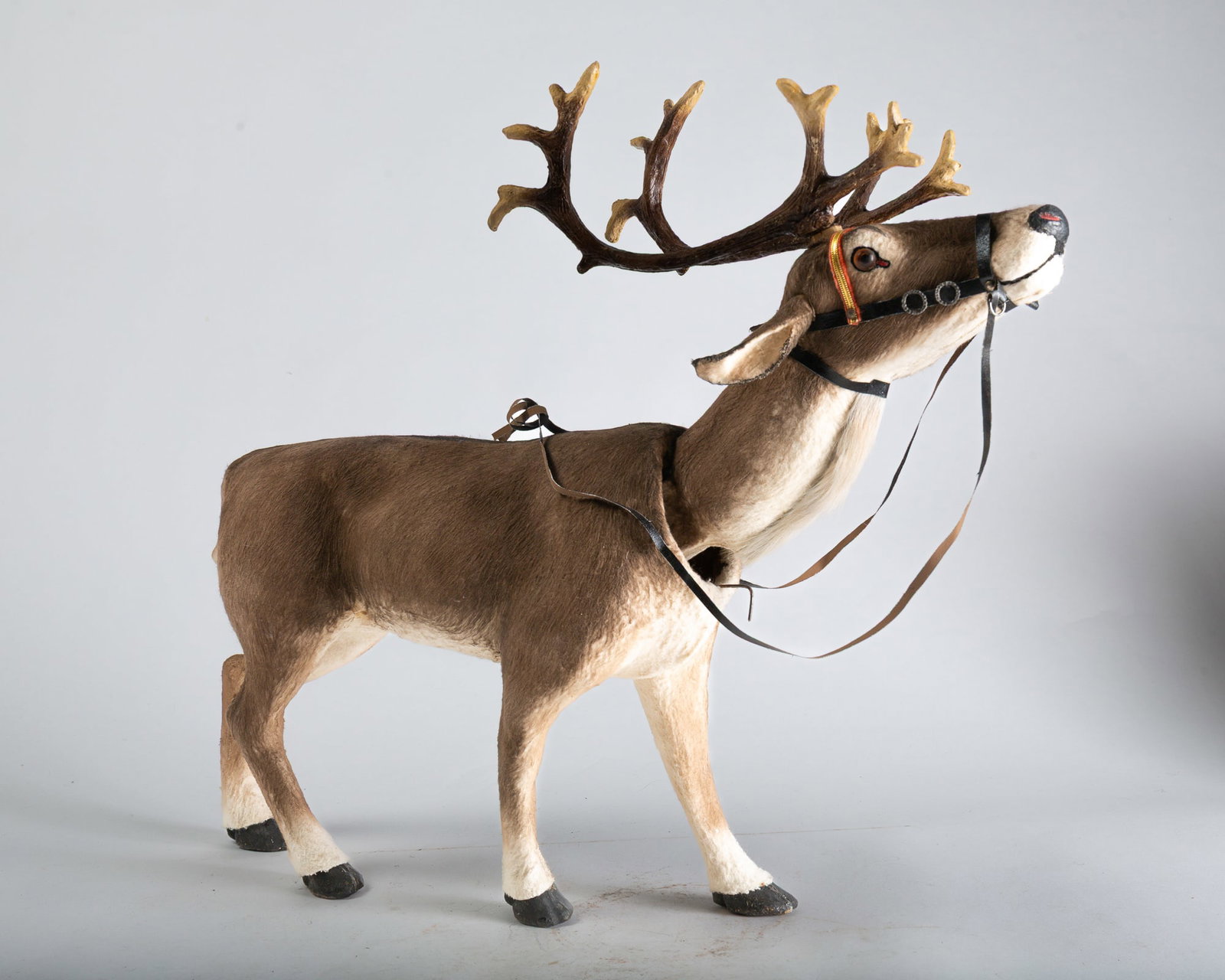 CLOCKWORK REINDEER FIGURE.: CLOCKWORK REINDEER FIGURE. Germany, early 20th Century. Reindeer with brown fur, brown glass eyes, a strip of real fur under its neck, a black nose with red nostrils, composition antlers, a black