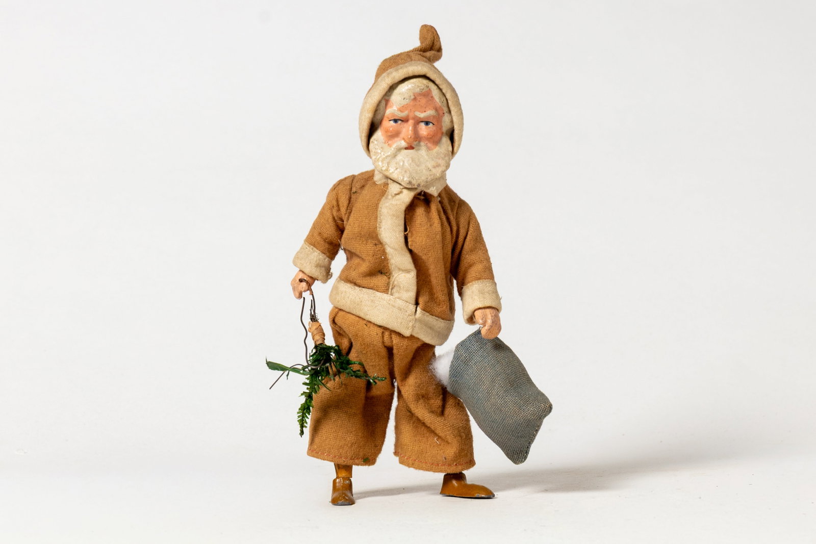 WIND-UP WALKING SANTA FIGURE.: WIND-UP WALKING SANTA FIGURE. Germany, early 20th Century. Santa with a painted composition face and hands, metal feet on wooden legs, a cardboard body, and wearing a faded short coat and pants with