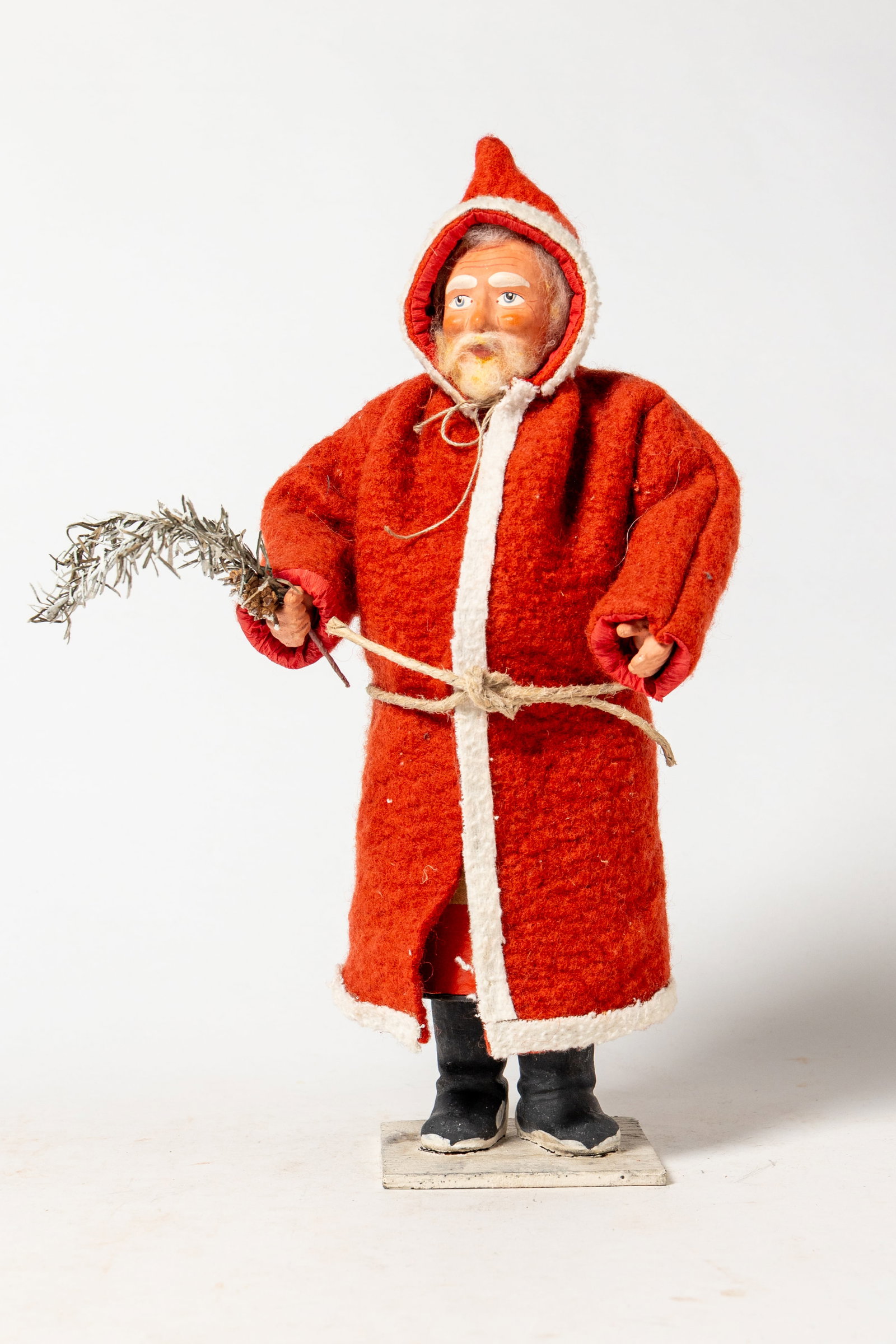 STANDING SANTA CANDY CONTAINER WITH HOODED RED COAT.: STANDING SANTA CANDY CONTAINER WITH HOODED RED COAT. Germany, early to mid- 20th Century. Depicting a standing Santa wearing a long red hooded coat with white trim, a rope belt, black boots, fur