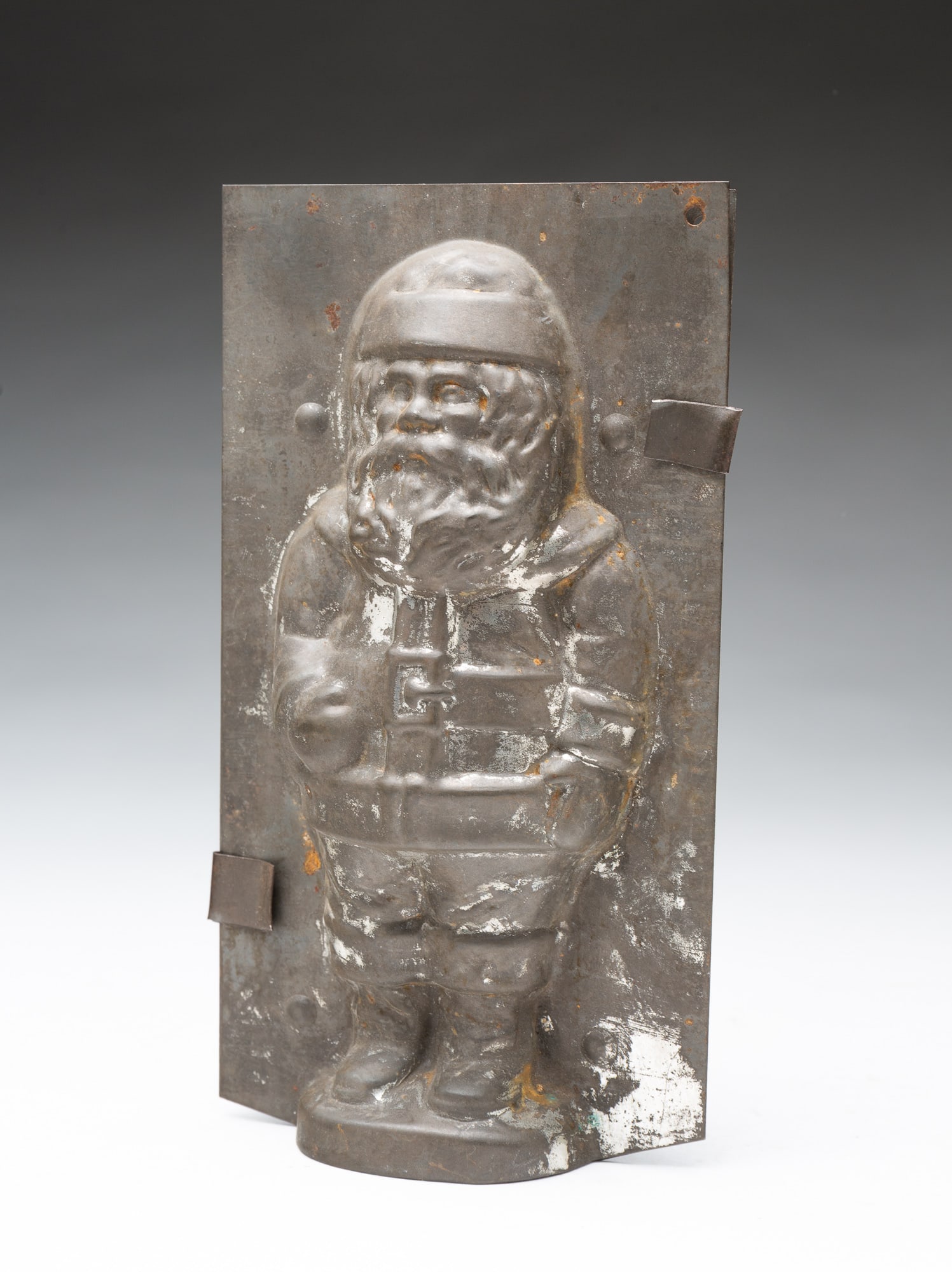 TIN SANTA CLAUS CHOCOLATE MOLD.: TIN SANTA CLAUS CHOCOLATE MOLD. American, early 20th Century. Standing Santa in traditional attire. 7.25"h. 4"w. 2"d.