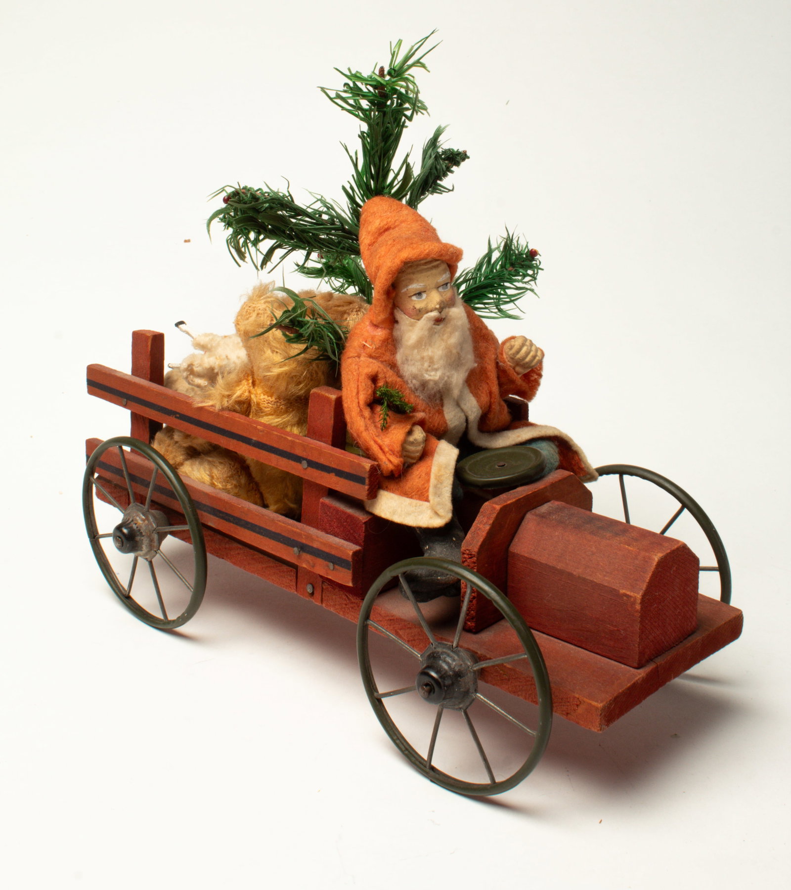 SANTA RIDING IN A WOODEN TRUCK.: SANTA RIDING IN A WOODEN TRUCK. Germany, early 20th Century. Santa wearing a long red felt coat, blue felt pants, a composition face and hands, and a cotton beard. He is driving a red-painted wooden t
