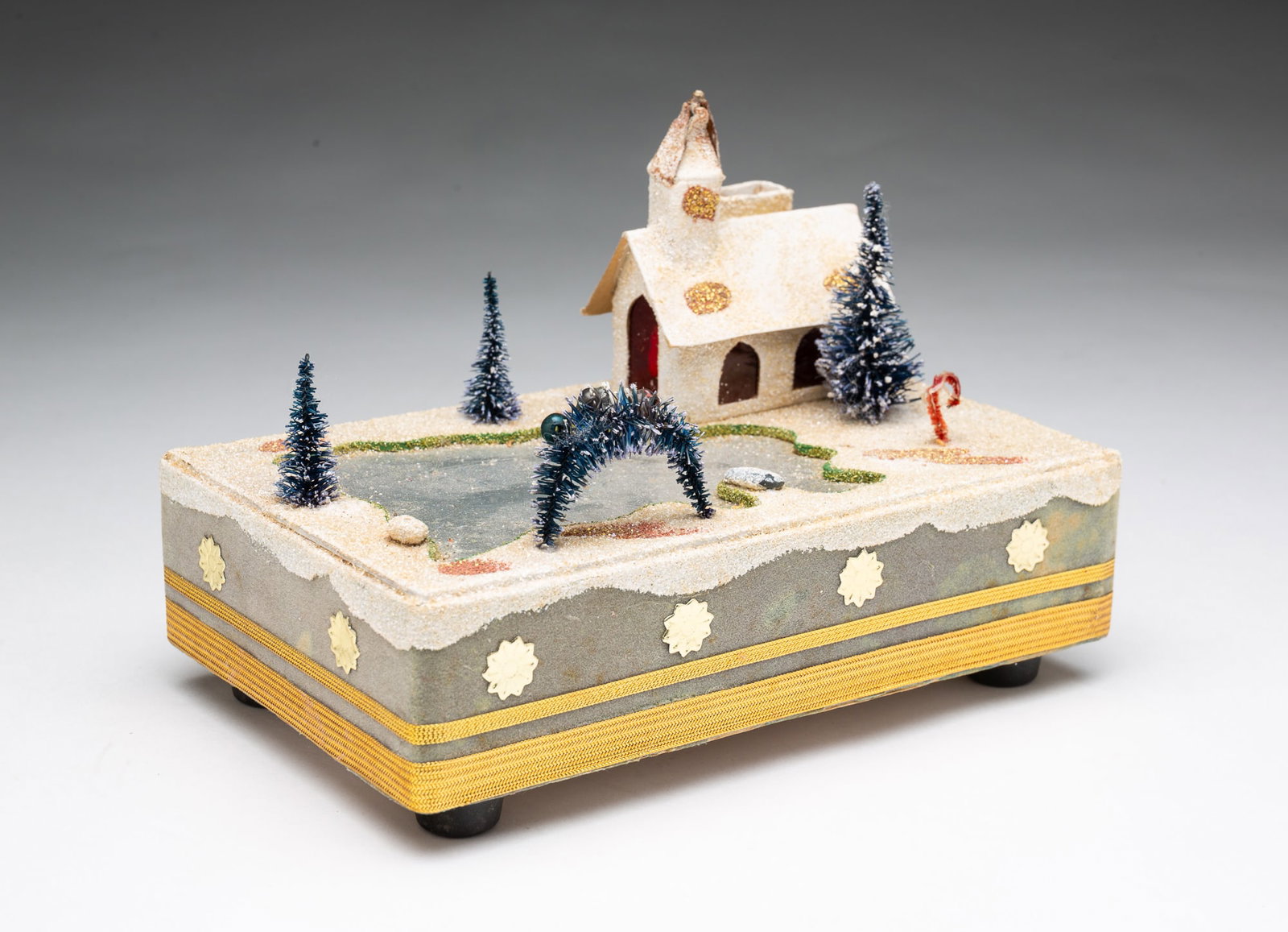SEARS MUSICAL LANDSCAPE WITH ICE-SKATING POND AND CHURCH.: SEARS MUSICAL LANDSCAPE WITH ICE-SKATING POND AND CHURCH. Japan, 20th Century. Originally made for Sears, music box constructed of paper and covered in mica snow with bottle brush trees, pond is