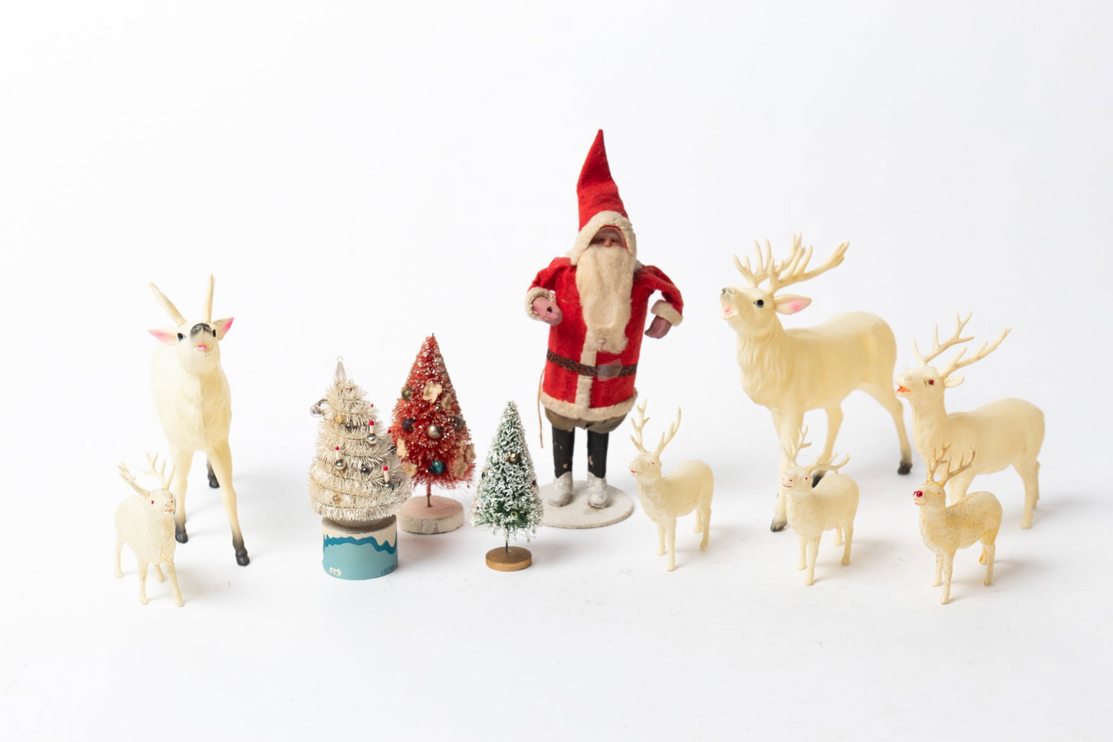 GROUP OF TEN JAPANESE CHRISTMAS DECORATIONS.: GROUP OF TEN JAPANESE CHRISTMAS DECORATIONS. Japan, 20th Century. Comprising a standing Santa with sack on his back holding a golden branch, two bottle brush trees with ornaments, and seven celluloid