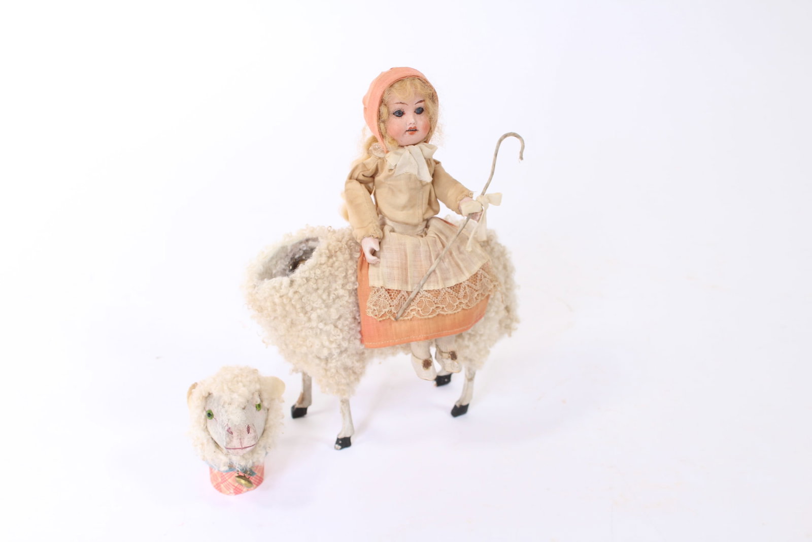 LITTLE BO PEEP RIDING ON LAMB CANDY CONTAINER.: LITTLE BO PEEP RIDING ON LAMB CANDY CONTAINER. Germany, early 20th Century. Bo Peep has a porcelain face, blue glass eyes, pink hat, and dress with a lacy apron, holding a staff. She sits atop a lamb