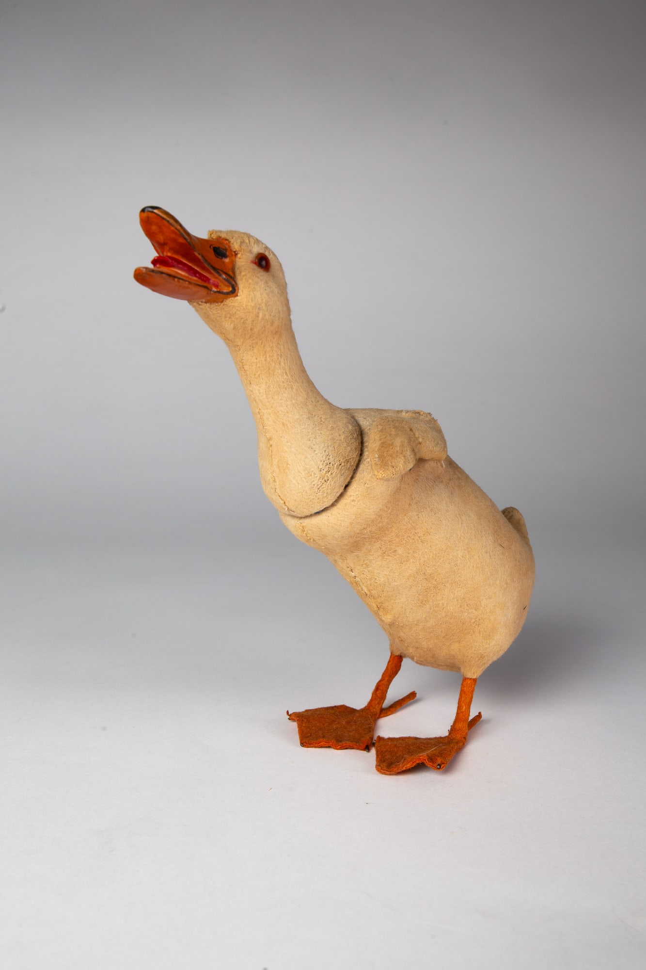LONG NECK GOOSE CANDY CONTAINER.: LONG NECK GOOSE CANDY CONTAINER. Germany, 20th Century. With glass eyes, large orange beak, and felt-covered body and feet; 9"h. 8"w. Provenance: Nancy Goff (Alliance, Ohio).