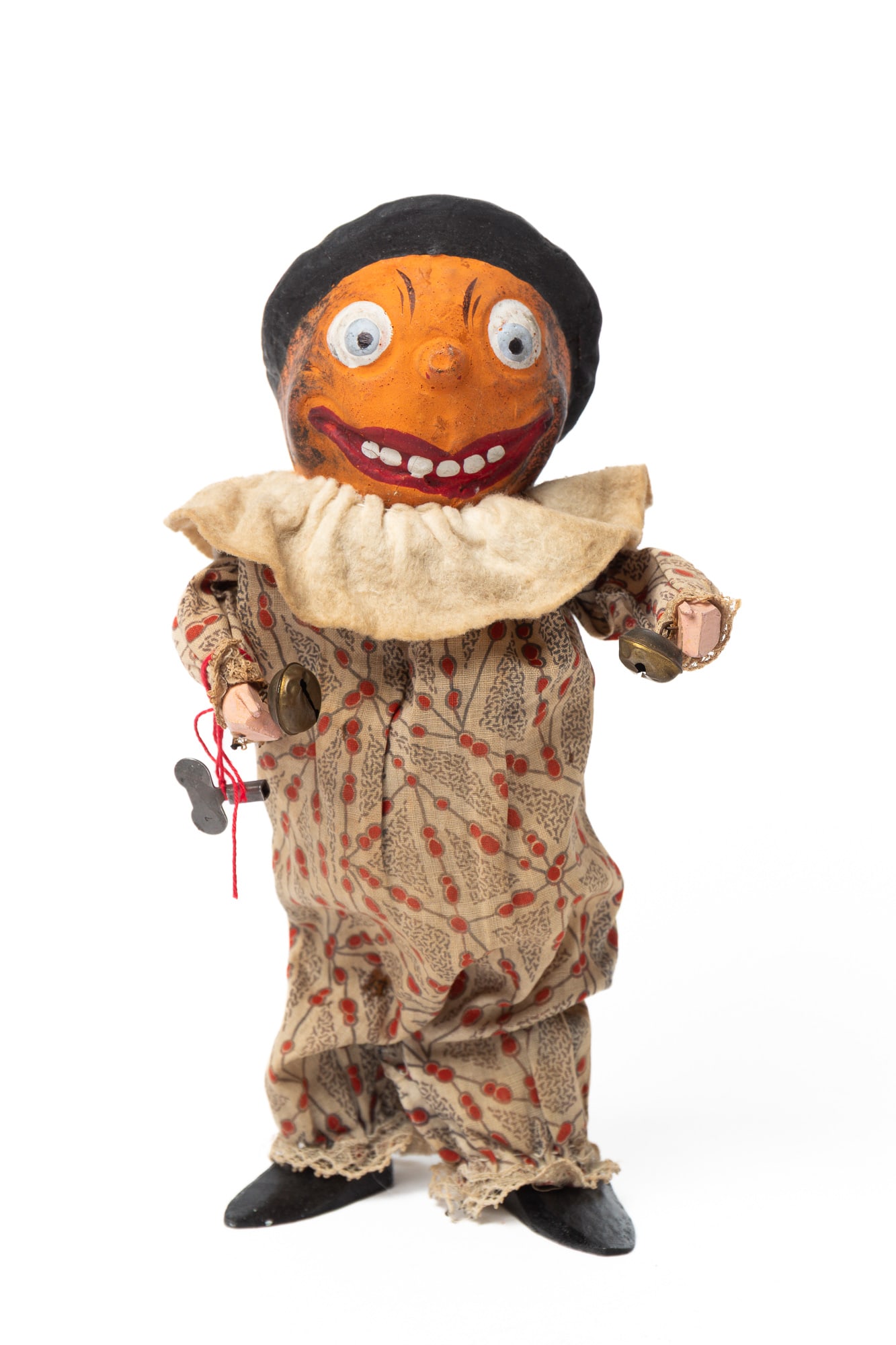 MECHANICAL PUMPKIN HEAD MAN.: MECHANICAL PUMPKIN HEAD MAN. Germany, early 20th Century. A composition pumpkin head with a painted face and hat, wooden hands with brass bells attached, wooden feet, and wearing a printed onesie
