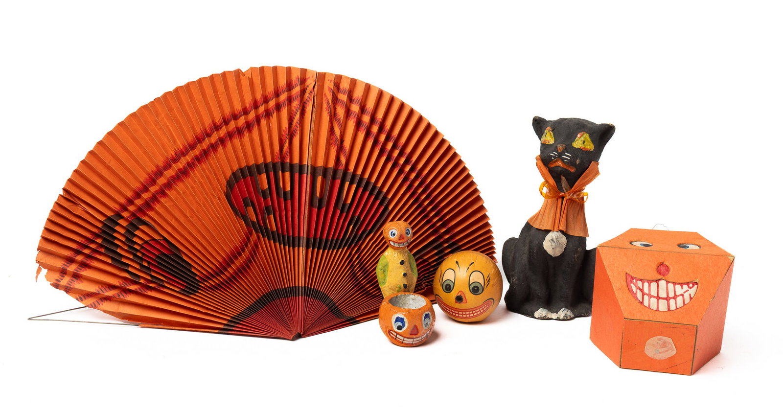 GROUPING OF EARLY HALLOWEEN DECORATIONS.: GROUPING OF EARLY HALLOWEEN DECORATIONS. Germany, early 20th Century. Including a spherical pumpkin head firecracker with fuse at nose with "Germany" paper label, a black cat candy container with a pa