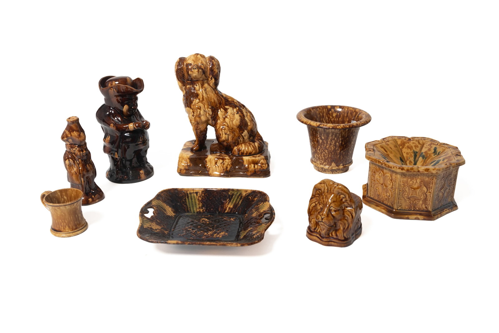 EIGHT ROCKINGHAM YELLOWWARE ITEMS.: EIGHT ROCKINGHAM YELLOWWARE ITEMS. English, mid- 19th Century. All eight have Rockingham brown mottled glaze. Includes a seated spaniel with free-standing front legs on a rectangular base, 12"h. A