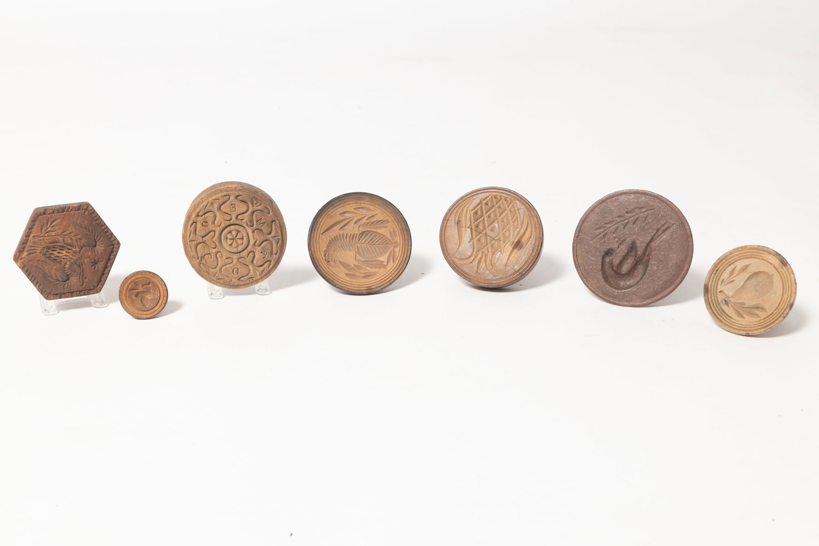 SEVEN CARVED BUTTER PRINTS.: SEVEN CARVED BUTTER PRINTS. American, 19th and early 20th Century. Mostly handled stamps featuring eagles, a pear, an acorn, a teasle, one with hearts, and a bird. From 5"h. to 1.75"h.