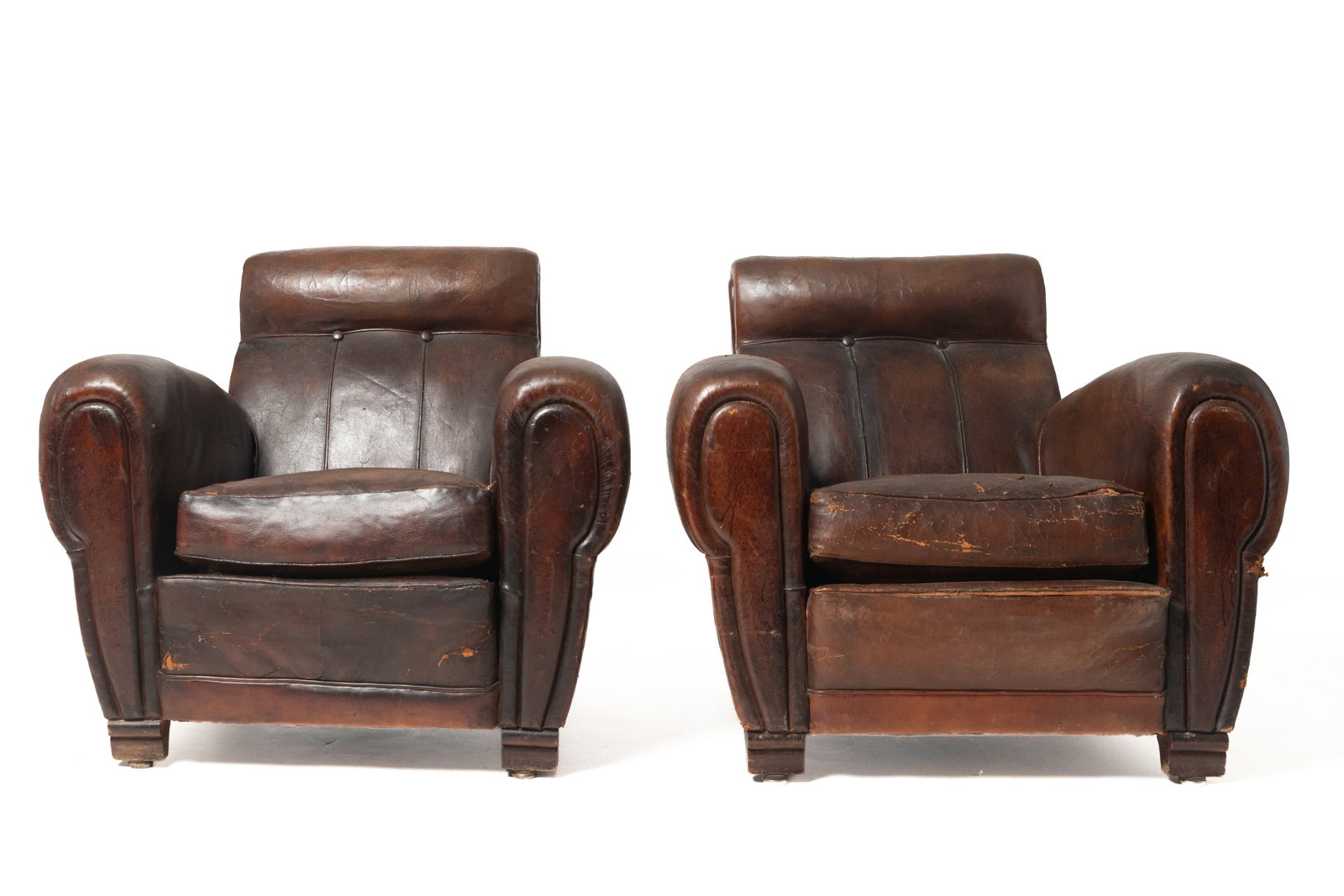 PAIR OF ART DECO LEATHER CLUB CHAIRS.: PAIR OF ART DECO LEATHER CLUB CHAIRS. American, mid- 20th Century. Rounded headrests, corded and two-button backs, rolled arms, and detached cushions. 17" seat. 33"h.