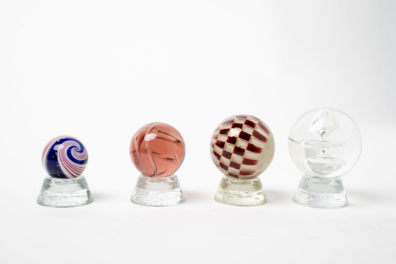 FOUR CONTEMPORARY STUDIO GLASS MARBLES.