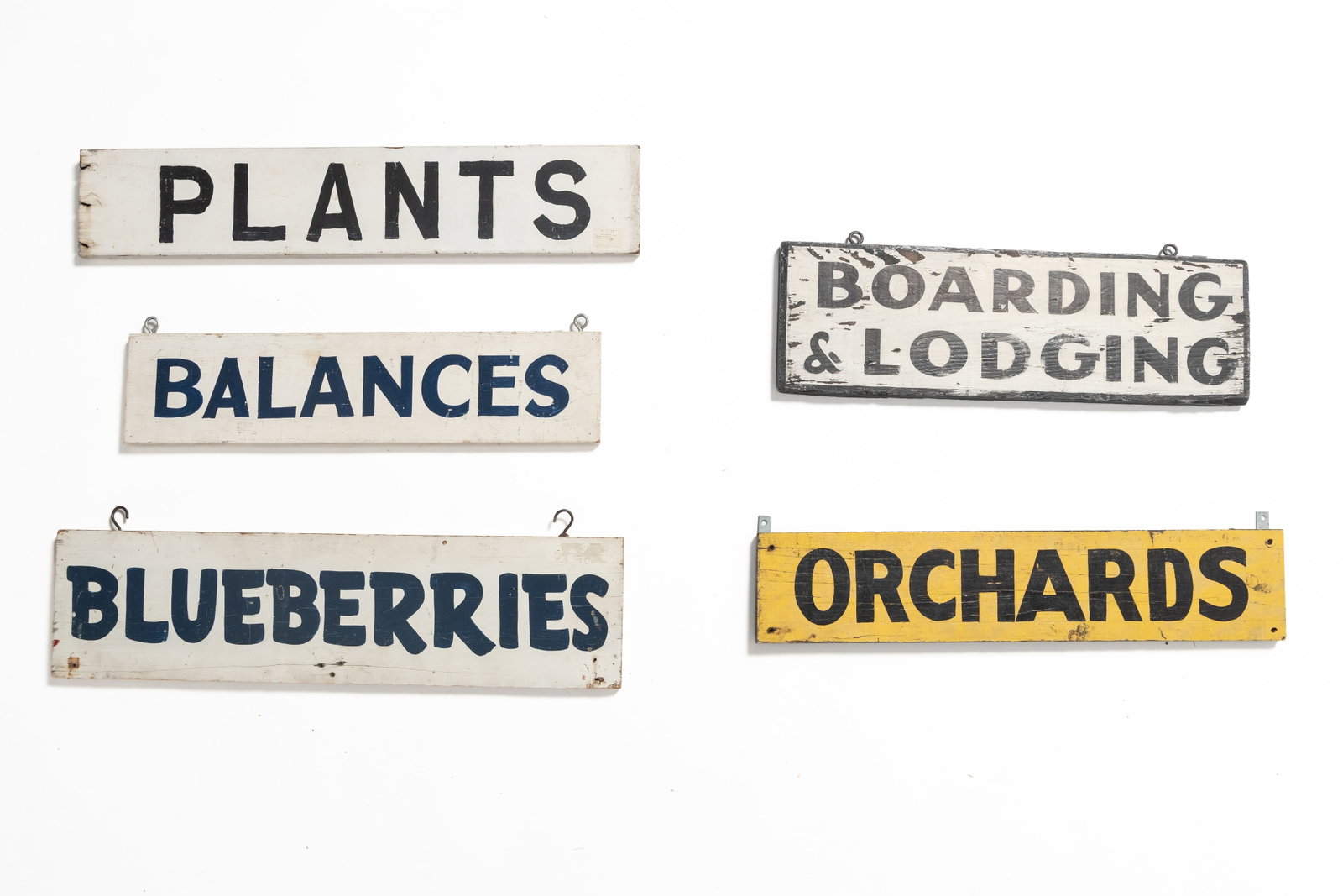FIVE HAND-PAINTED WOOD SIGNS.: FIVE HAND-PAINTED WOOD SIGNS. American, 20th Century. Each of rectangular form with sold lettering on solid ground, four with hanging hardware, comprising "ORCHARDS," "PLANTS," BLUEBERRIES,"