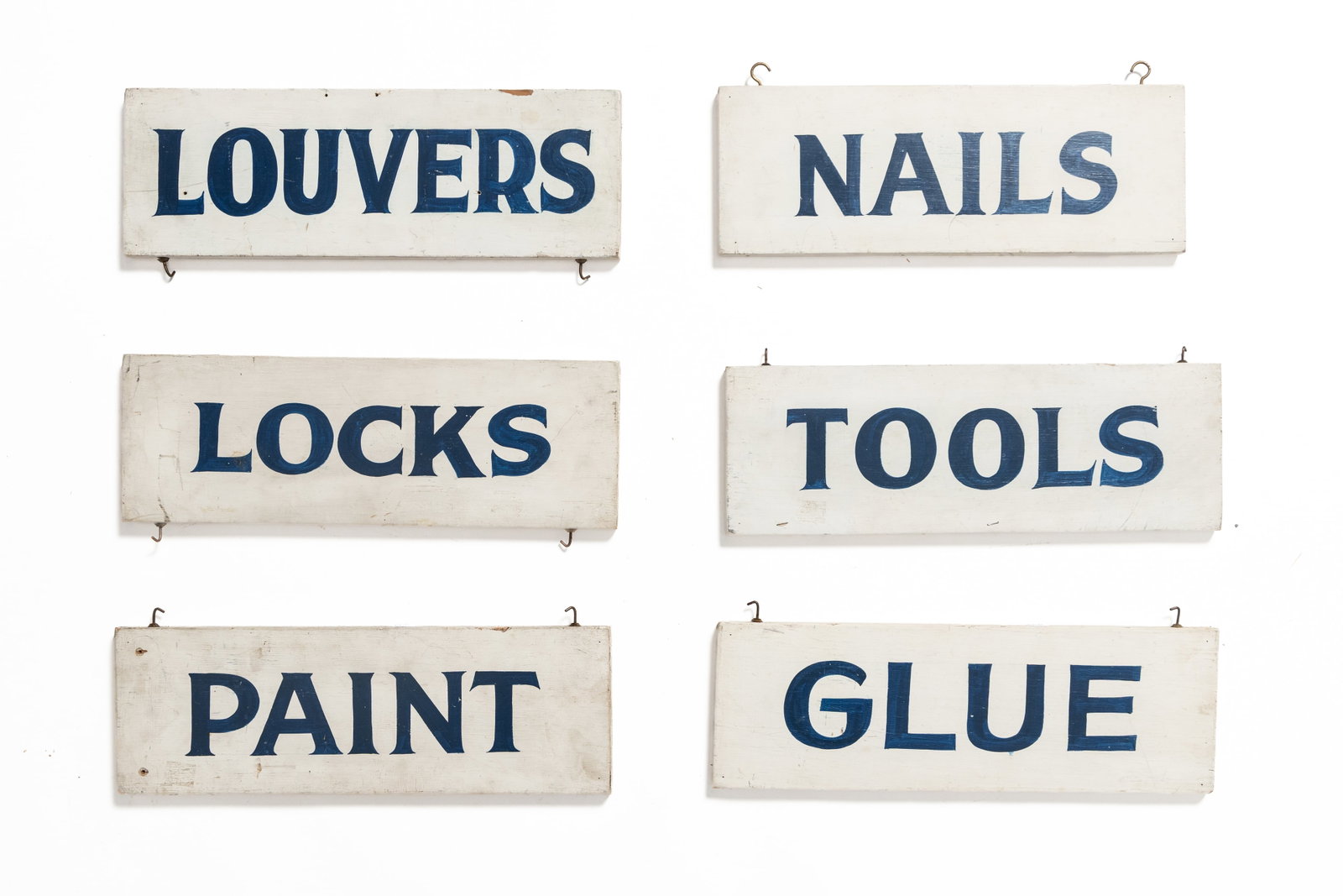 SIX DOUBLE-SIDED HAND-PAINTED WOOD HARDWARE SIGNS.: SIX DOUBLE-SIDED HAND-PAINTED WOOD HARDWARE SIGNS. American, 20th Century. Each of rectangular form having blue lettering on white ground with two hooks for hanging, comprising "NAILS," "LOCKS,"