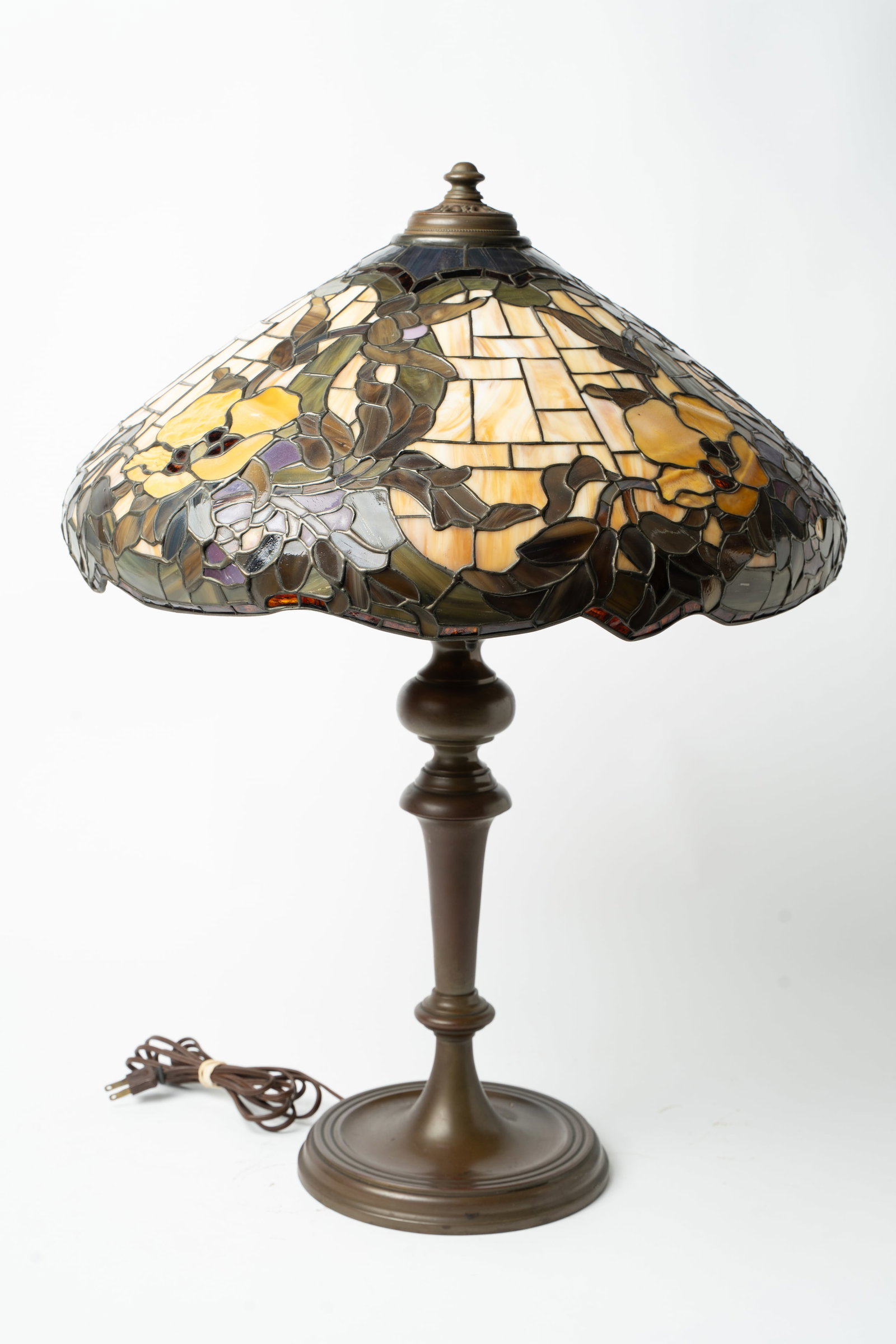 STAINED GLASS TABLE LAMP.: STAINED GLASS TABLE LAMP. 20th Century. Floral patterned shade in multicolored slag and clear glass, scalloped rim, and locking shade ring. Old base with triple-socket fixture and new cap. 27.5"h.