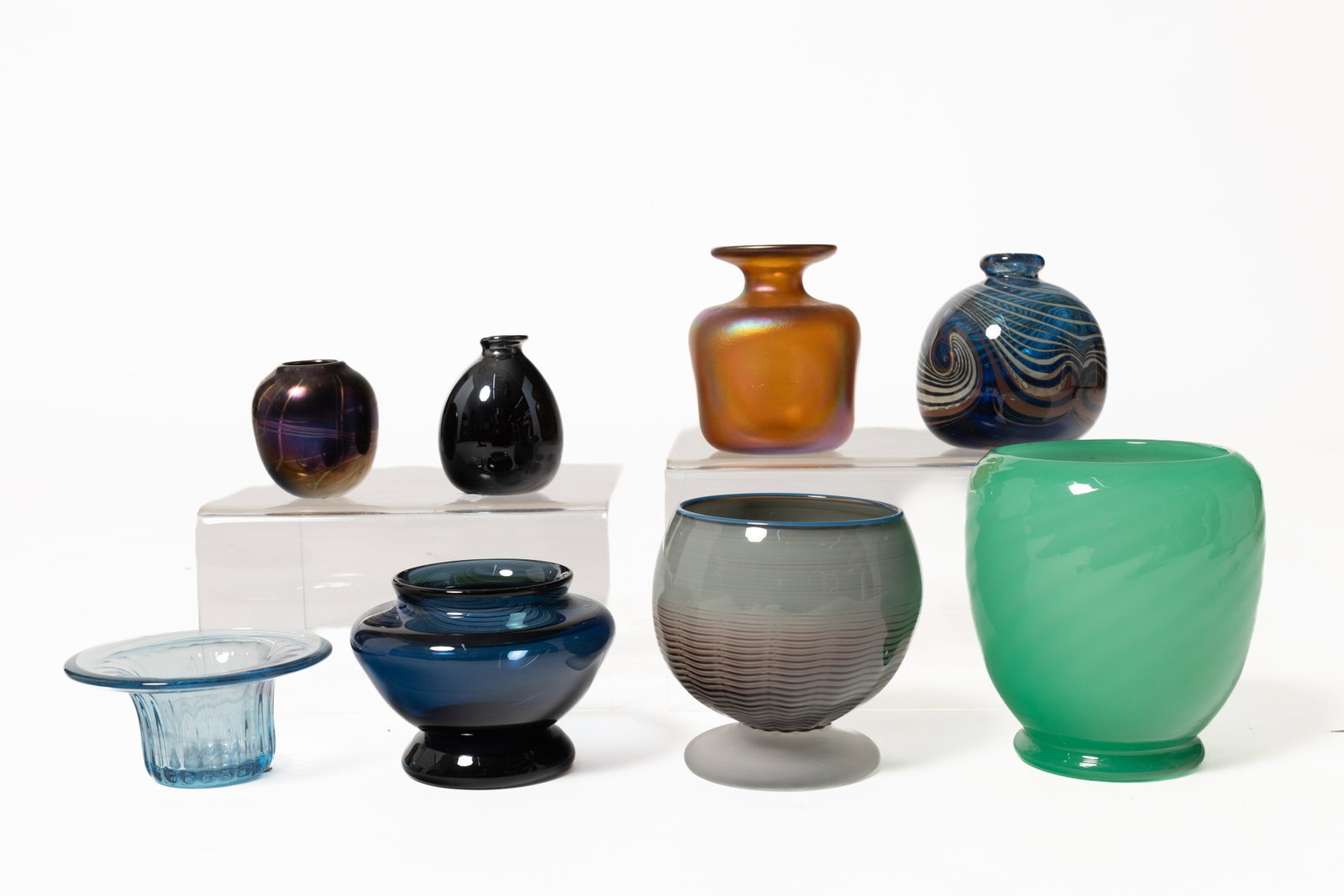EIGHT STUDIO GLASS VASES.: EIGHT STUDIO GLASS VASES. American, late 20th Century. Comprising a Marko Mathews footed vase with a grey and brown striped bowl and a frosted boot dated 1987, 5.75"h. A Mark Vance blue-ribbed vase