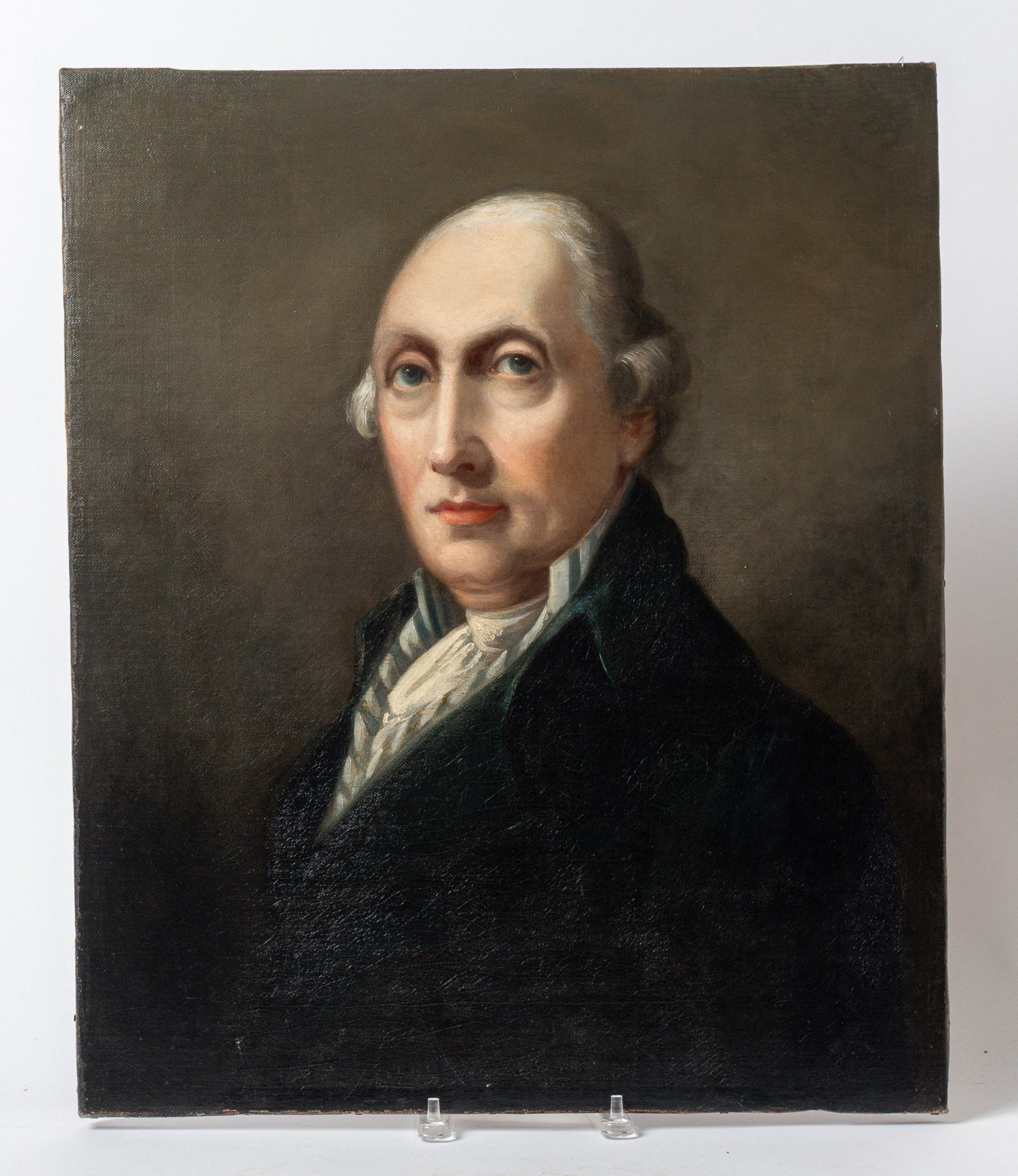 AMERICAN SCHOOL OIL ON CANVAS PORTRAIT OF A GENTLEMAN.: AMERICAN SCHOOL OIL ON CANVAS PORTRAIT OF A GENTLEMAN. Late 18th or early 19th Century. Bust portrait of a gentleman with white hair, large eyes and a slight smirk on his face, wearing a striped