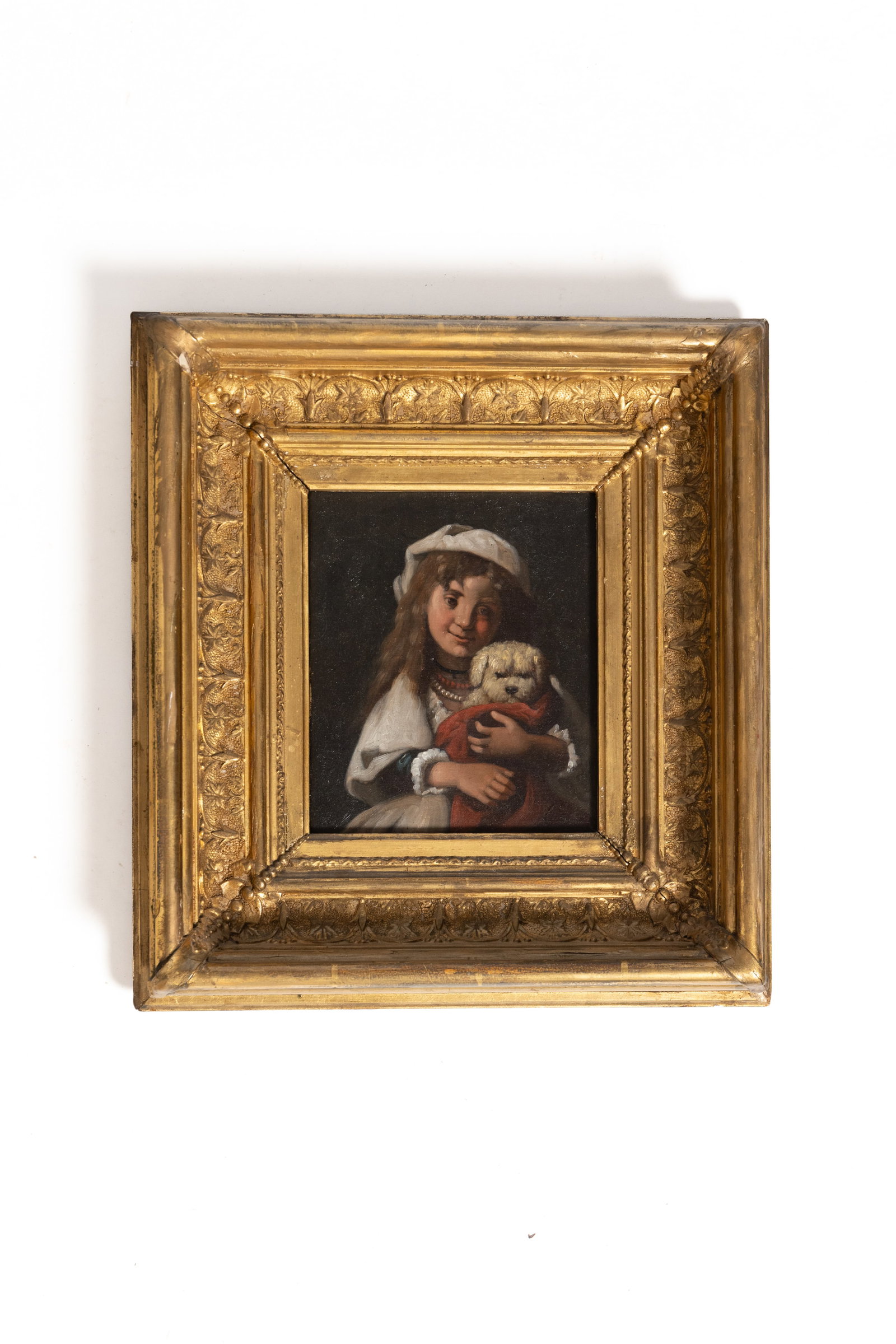 EUROPEAN SCHOOL OIL ON CANVAS OF A CHILD AND DOG.: EUROPEAN SCHOOL OIL ON CANVAS OF A CHILD AND DOG. Late 19th Century. Unsigned. Depiction of a young child with long hair and wearing a white hat holding their dog wrapped in a red throw. In an ornate 