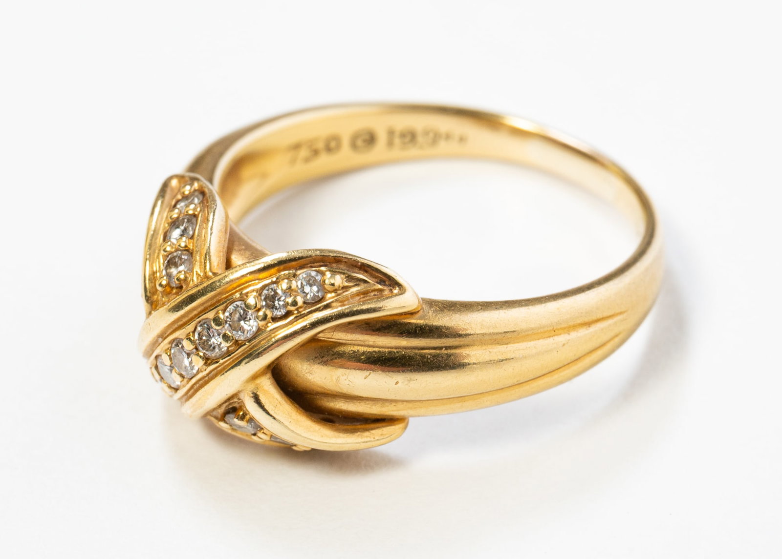 TIFFANY & CO. 18K YELLOW GOLD DIAMOND SIGNATURE X COCKTAIL RING.: TIFFANY & CO. 18K YELLOW GOLD DIAMOND SIGNATURE X COCKTAIL RING. American, contemporary. 18k yellow gold. Band with a central "x" set with 15 round diamonds, band engraved "750 1990 (TIFFAN)Y & CO.".
