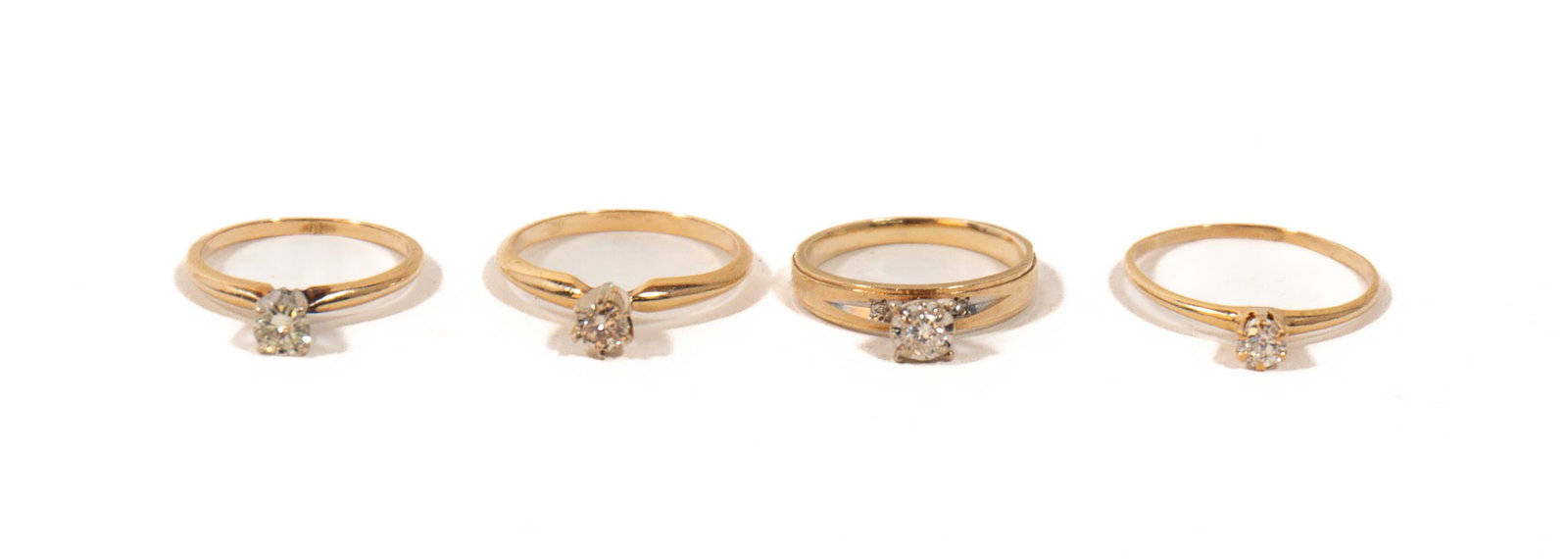 FOUR 14K YELLOW GOLD DIAMOND SOLITAIRE RINGS.: FOUR 14K YELLOW GOLD DIAMOND SOLITAIRE RINGS. Contemporary. A thin yellow gold band, white gold prong setting, holding a single round brilliant cut diamond, K/SI2, 0.22 ct., size 5; a thin yellow