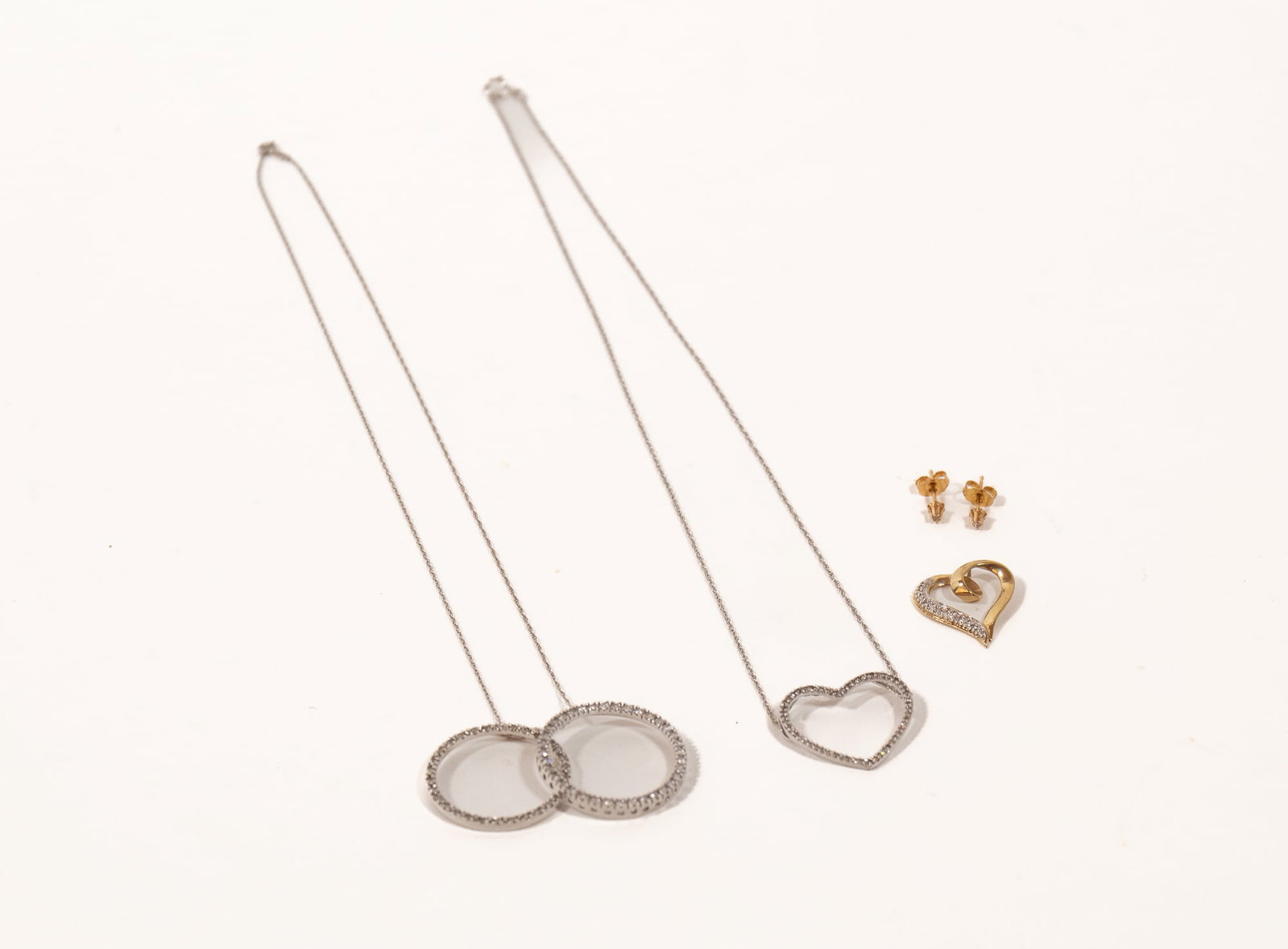 GROUP OF GOLD AND GEMSTONE JEWELRY.: GROUP OF GOLD AND GEMSTONE JEWELRY. Contemporary. A pair of dainty, 14k yellow gold diamond chip post-back earrings, a 10k white gold open-heart diamond pendant necklace, set with fifty-six prong-set