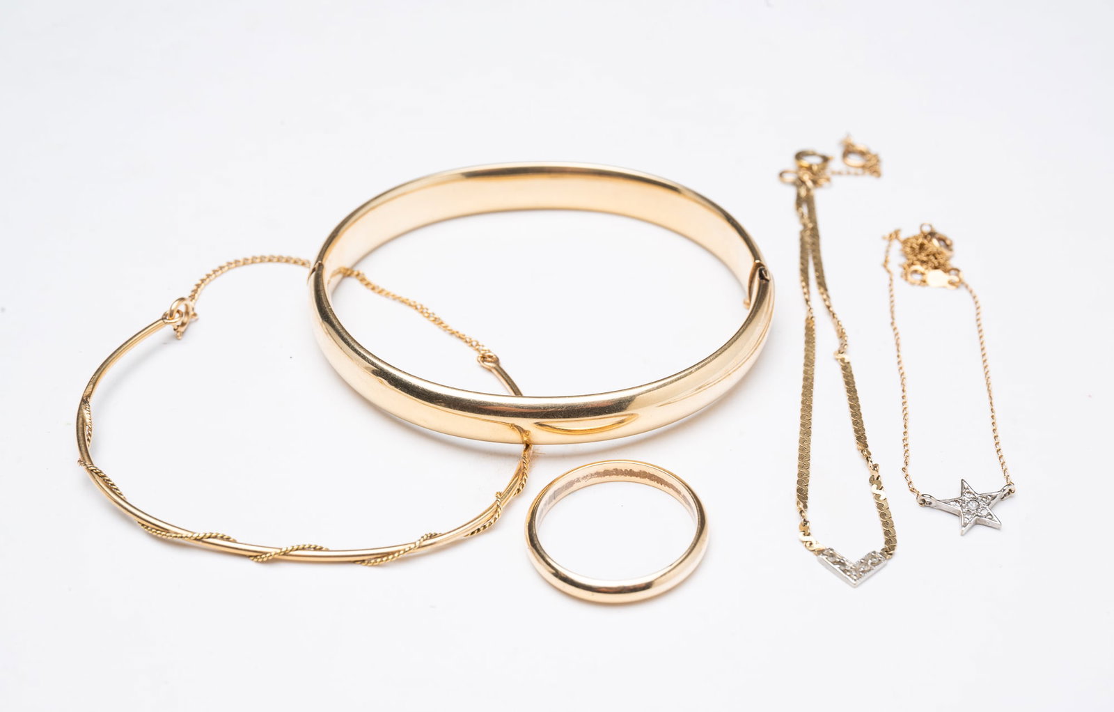 GROUP OF 14K YELLOW GOLD JEWELRY.: GROUP OF 14K YELLOW GOLD JEWELRY. Contemporary. Includes a bangle, a flat link anklet with a gemstone accent, 8.5"l., a twisted wire-wrapped bracelet, a wedding band, size 10, and a dainty necklace