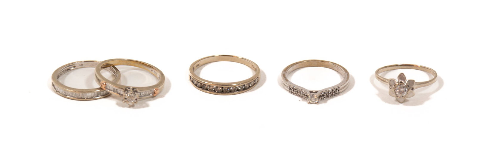 FIVE 10K WHITE GOLD AND DIAMOND RINGS.: FIVE 10K WHITE GOLD AND DIAMOND RINGS. Contemporary. A flower-style ring set with a center round brilliant-cut diamond, H/I2, 0.15ct., size 5.75., a band with twelve channel-set diamonds, I/I3, 0.35ct