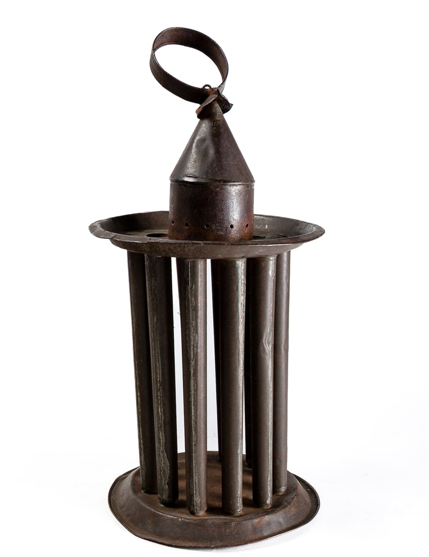 TWELVE-TUBE CIRCULAR CANDLE MOLD.: TWELVE-TUBE CIRCULAR CANDLE MOLD. American, 19th Century. Circular form twelve-tube candle mold, shaped top with ring handle, and resting on base. 18"h. 8"d. Provenance: Nancy Goff (Alliance, Ohio).