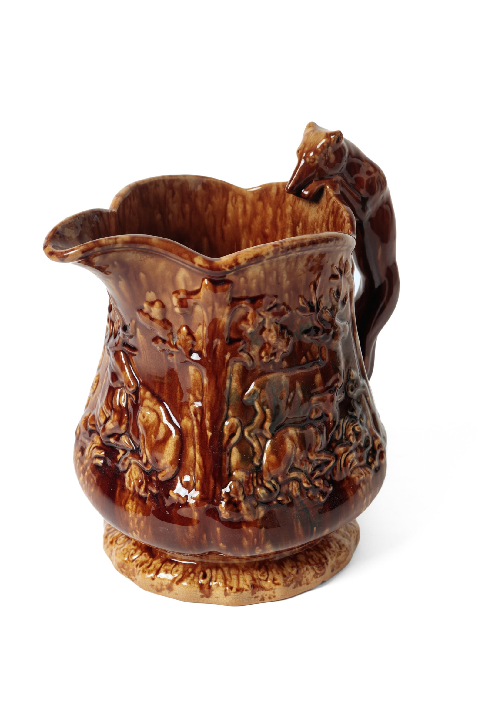 ROCKINGHAM FLINT ENAMEL HOUND-HANDLED PITCHER.: ROCKINGHAM FLINT ENAMEL HOUND-HANDLED PITCHER. English, 19th Century. Paneled form with molded scenes of deer, footed bottom, and an applied hound handle. 9.75"h. Cataloger's Note: Reputedly from the