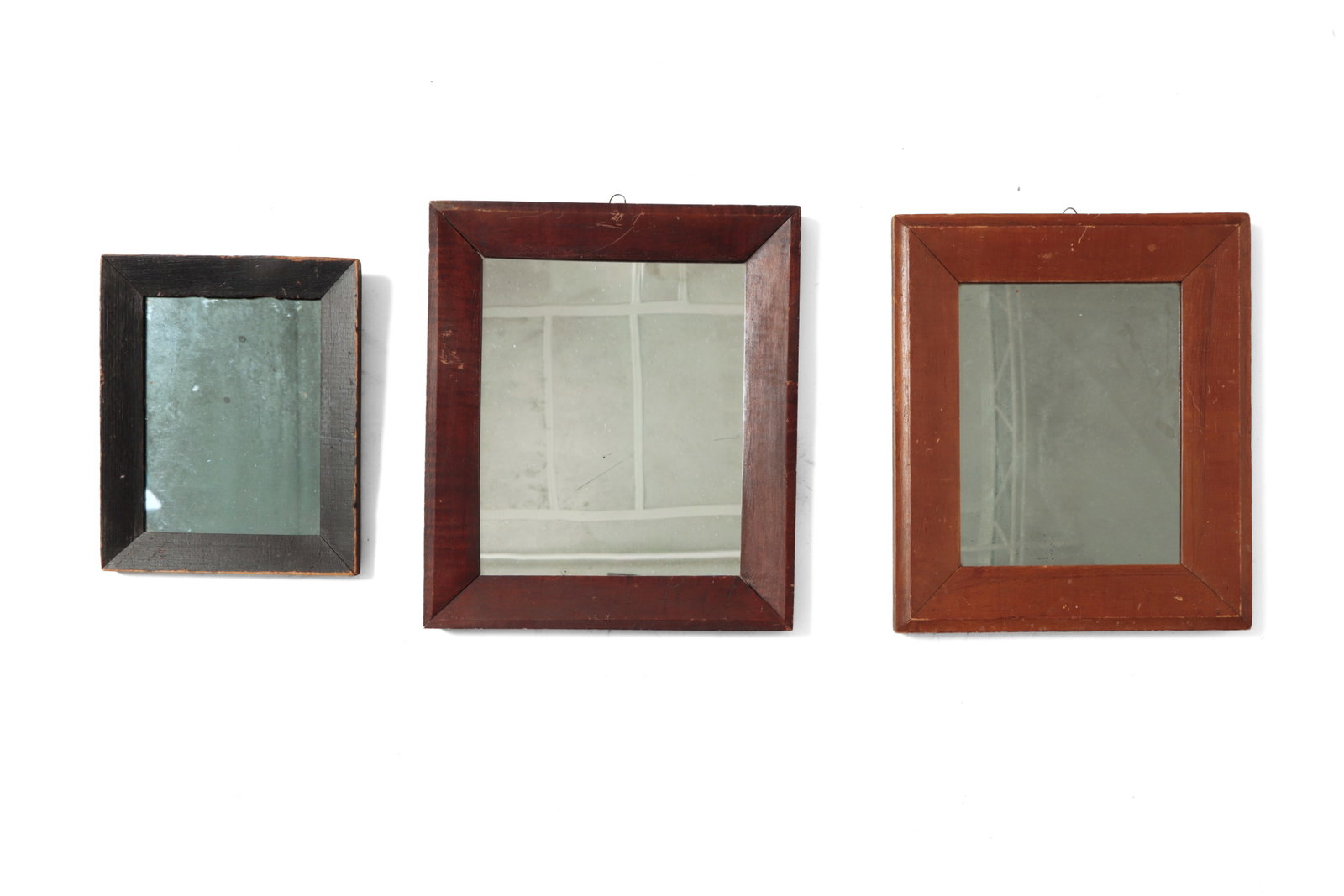 THREE EARLY MIRRORS IN BEVELED AND MITERED FRAMES.: THREE EARLY MIRRORS IN BEVELED AND MITERED FRAMES. American, 19th Century. The first in a black-painted frame, the second in a tiger maple frame with diagonal lap joints and alligatored finish (Ex
