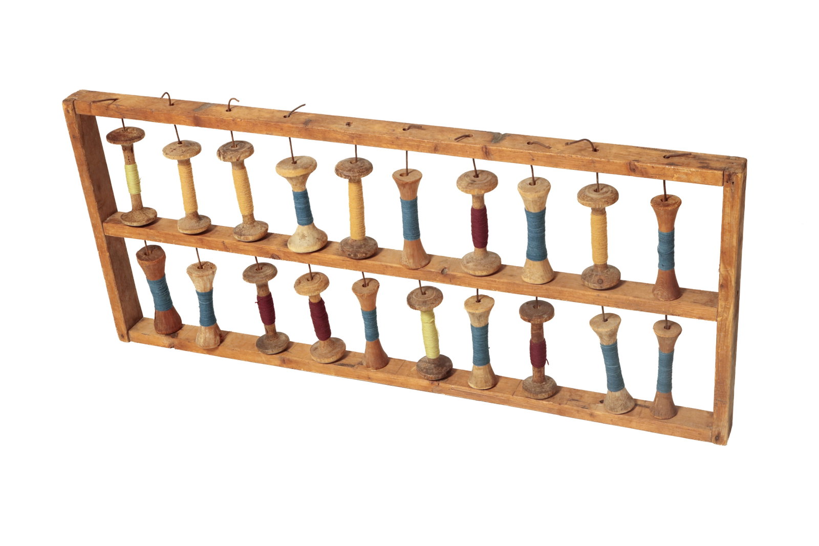 WOODEN YARN BOBBIN RACK.: WOODEN YARN BOBBIN RACK. American, 19th Century. Pine. Standing rack with ladder-style wooden frame having mortised joints with square nails, holding 20 wooden yarn bobbins on metal wires. 22.5"h.