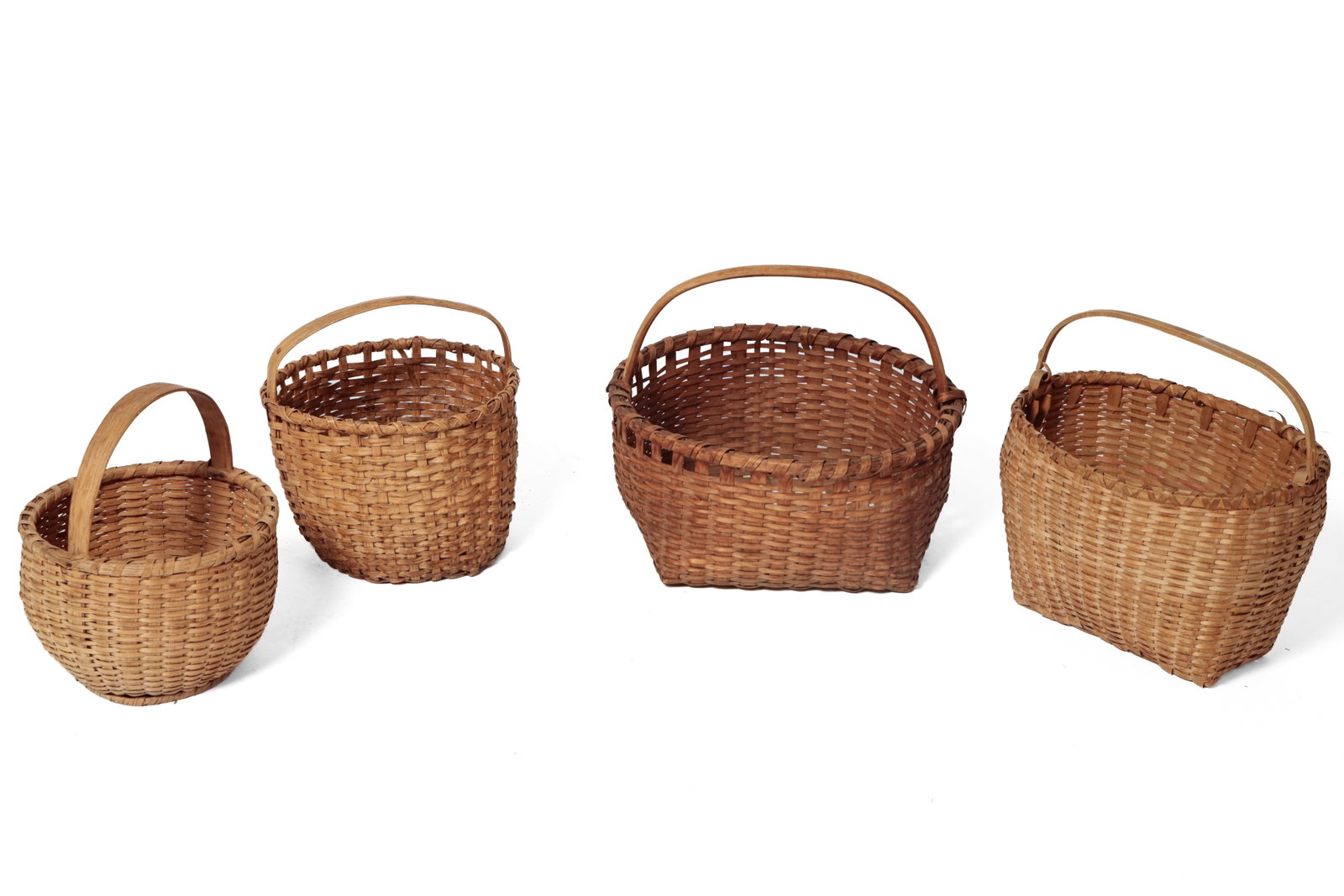 FOUR WOVEN SPLINT BASKETS.: FOUR WOVEN SPLINT BASKETS. American, 20th Century. All with bentwood handles and wrapped top rims. Round rim with square base, 14"h. Faded polychrome oval form with swing handle, 11"h. Two round